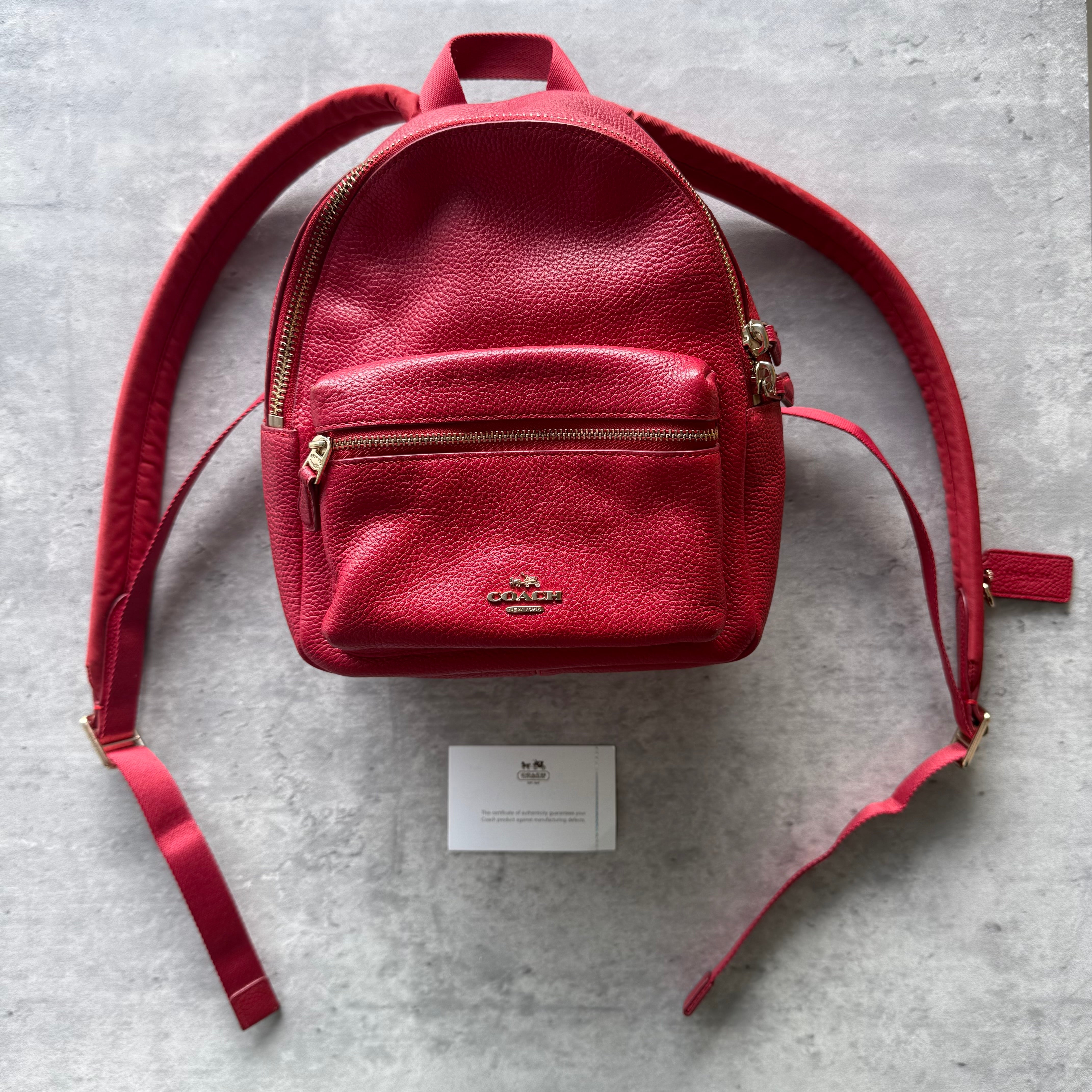 Coach Mini Charlie Backpack Red, crafted from pebbled leather with gold-tone hardware, front zip pocket, and adjustable shoulder straps.