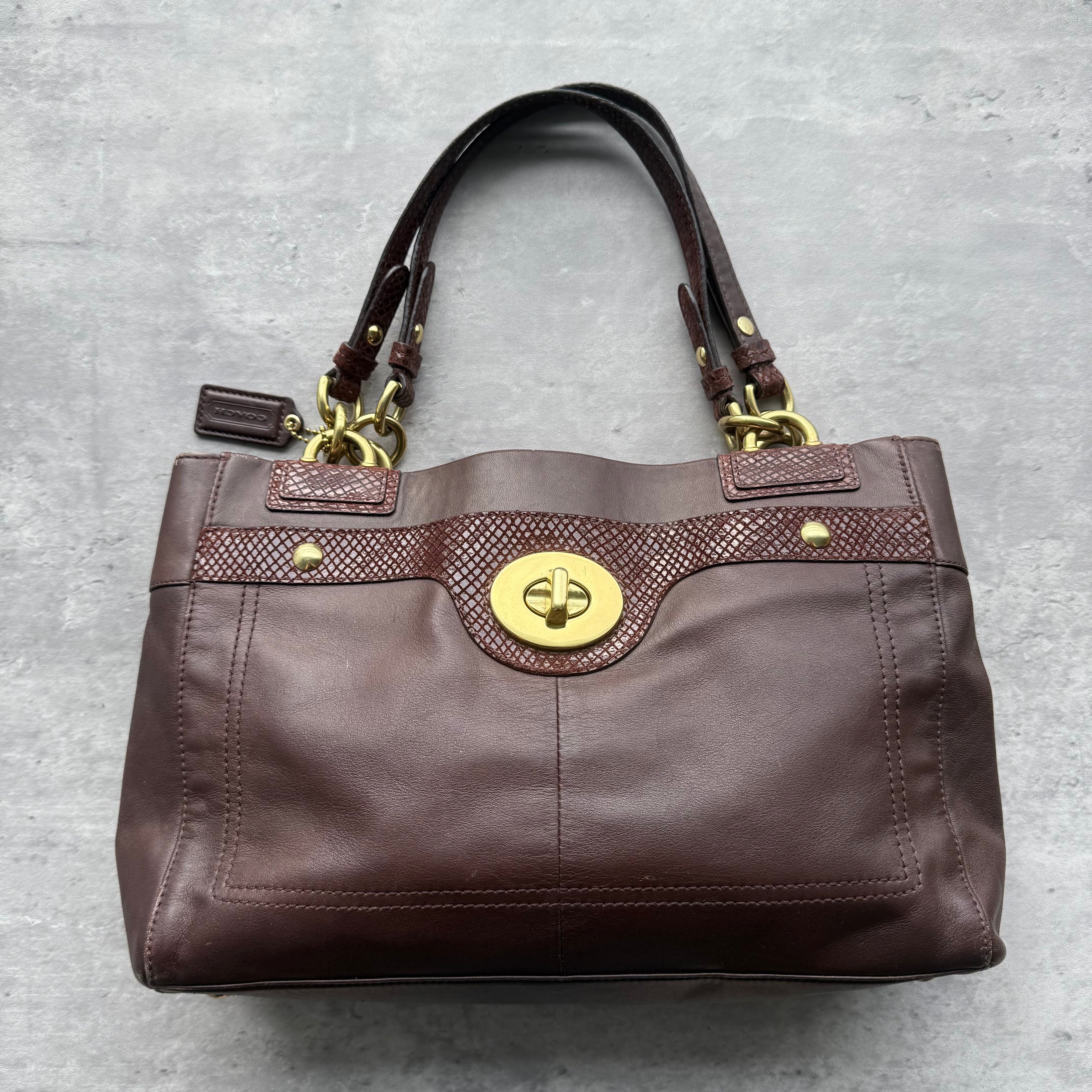 Coach Penelope Pebbled Leather Handbag Brown with gold-tone turn-lock closure, snake-embossed trim, and structured dual-handle design, featuring spacious interior compartments.