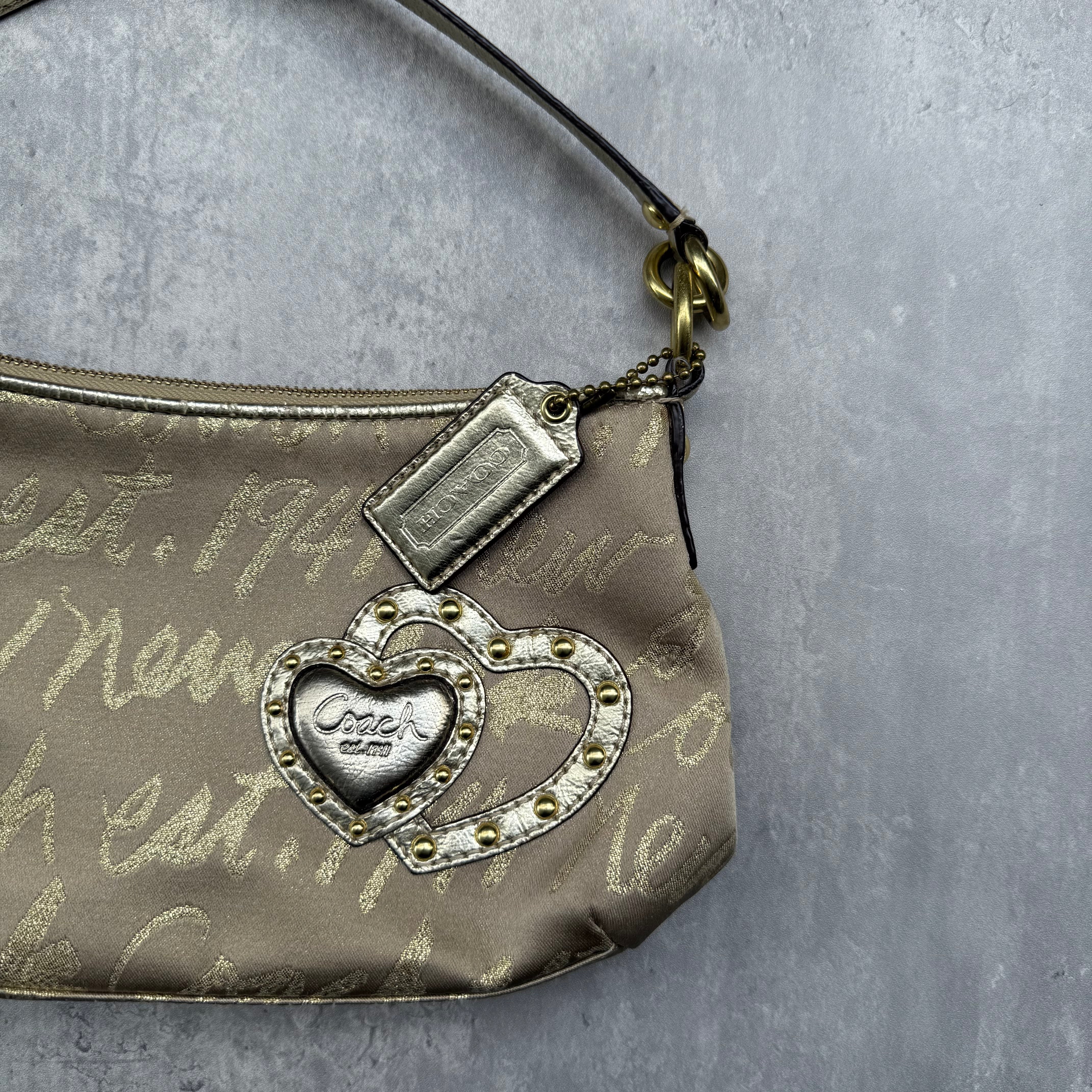 Coach Script Heart Shoulder Bag in beige satin with crystal heart charm, lavender interior, and gold-tone hardware.