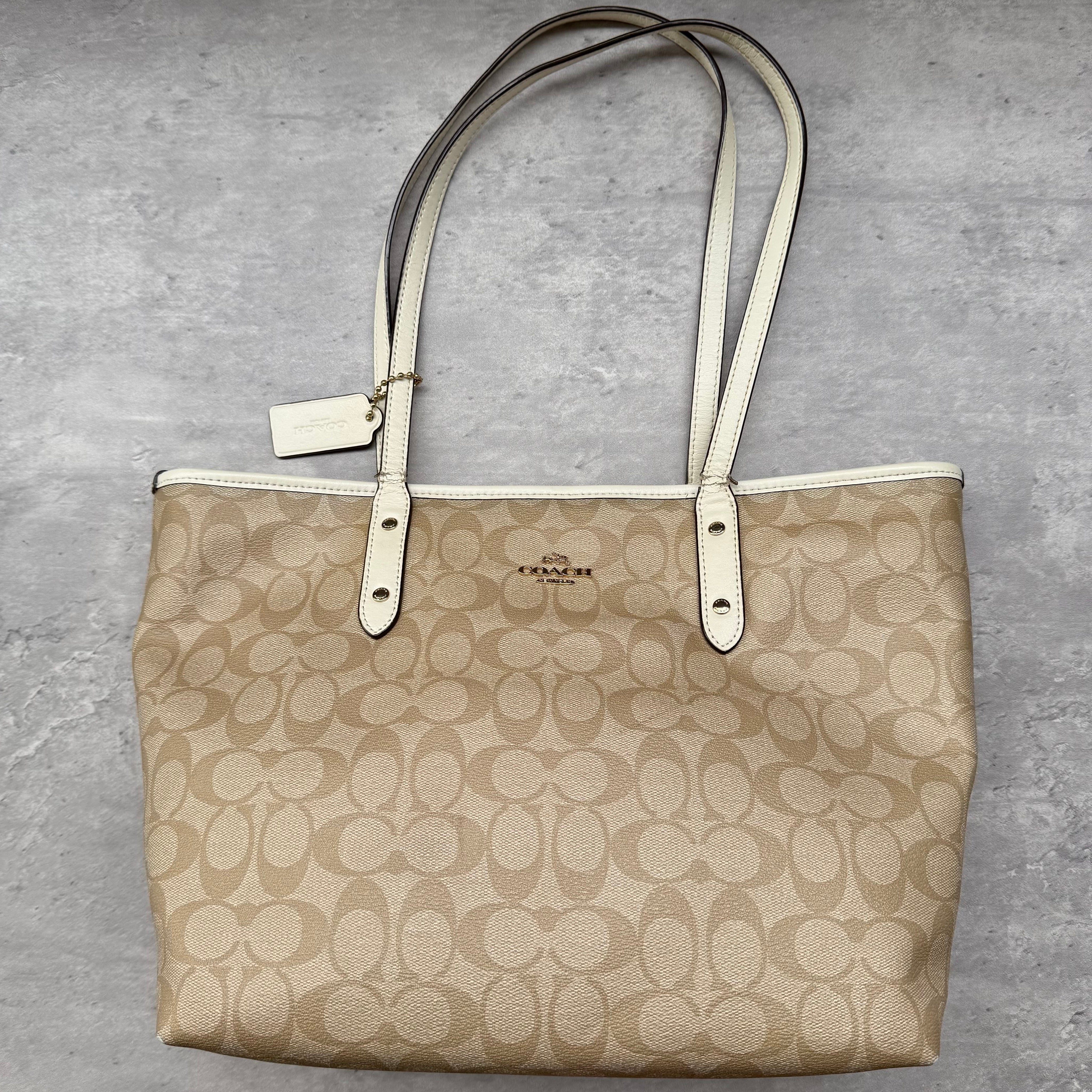 Coach Signature Canvas City Tote Bag Beige and White, featuring iconic monogram print with leather handles and zip closure
