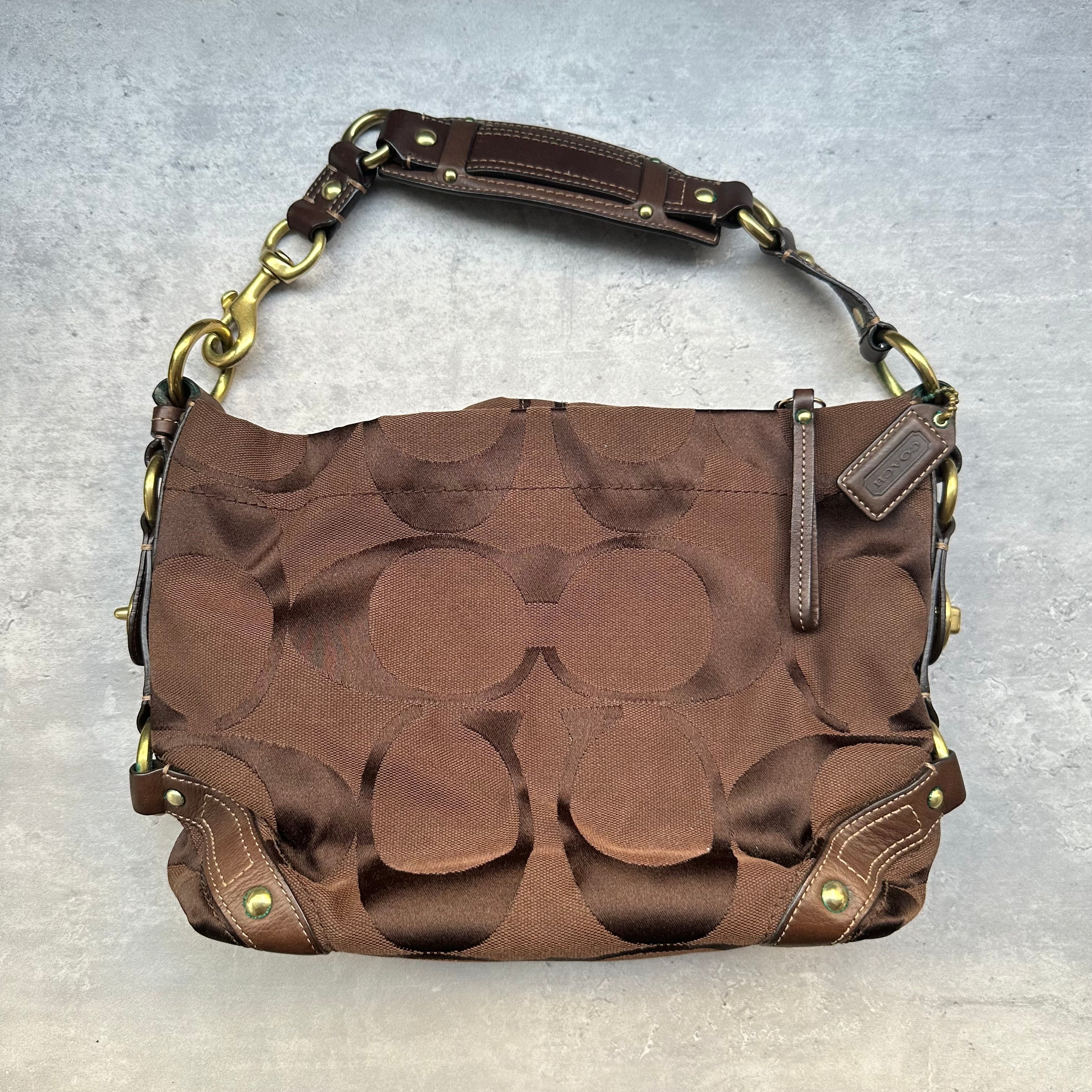 Coach Signature Canvas Hobo Shoulder Bag in brown jacquard fabric, featuring brass hardware, leather trim, and a zip-top closure.