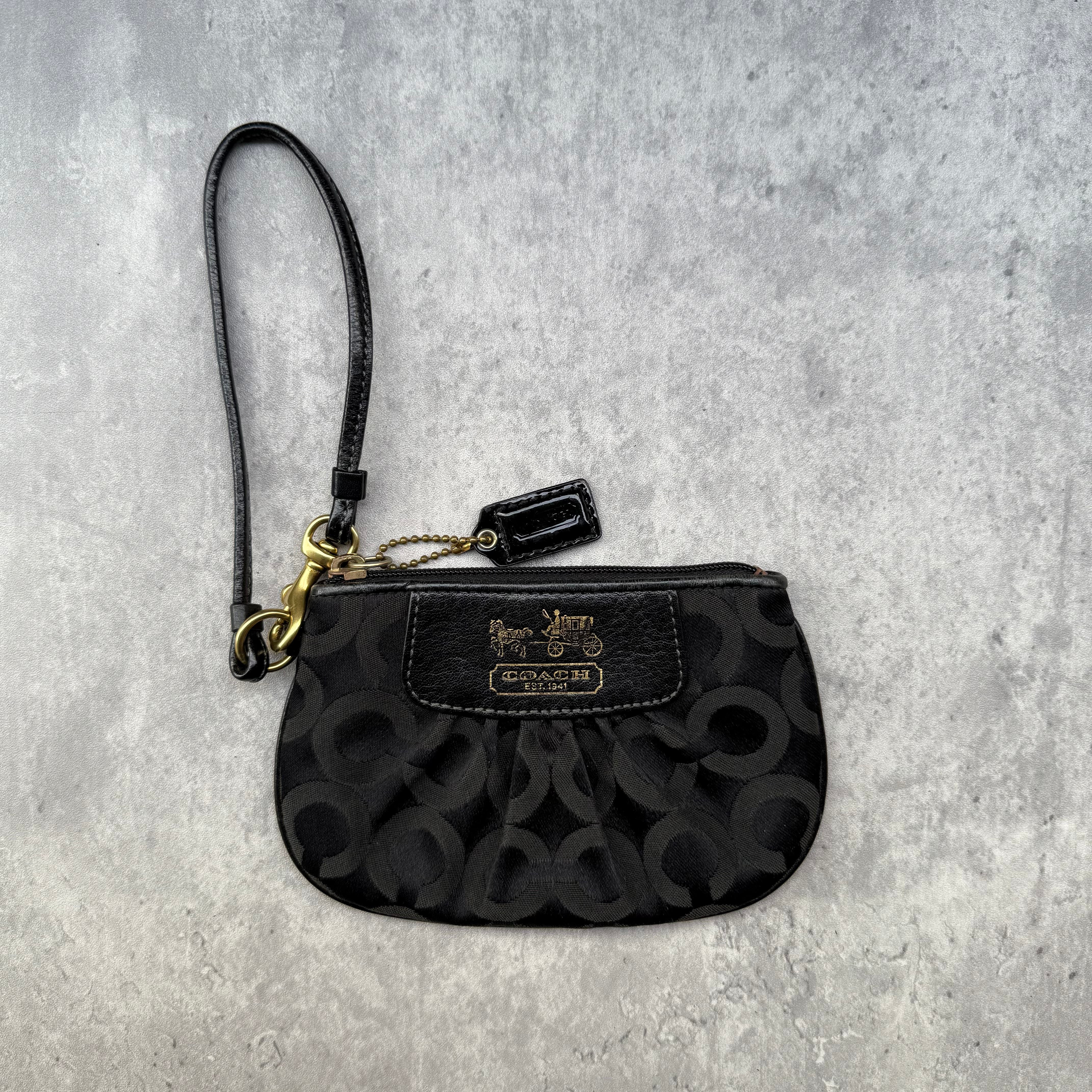 Coach Signature Canvas Wristlet Black with monogram jacquard, leather trim, and gold Coach logo plaque