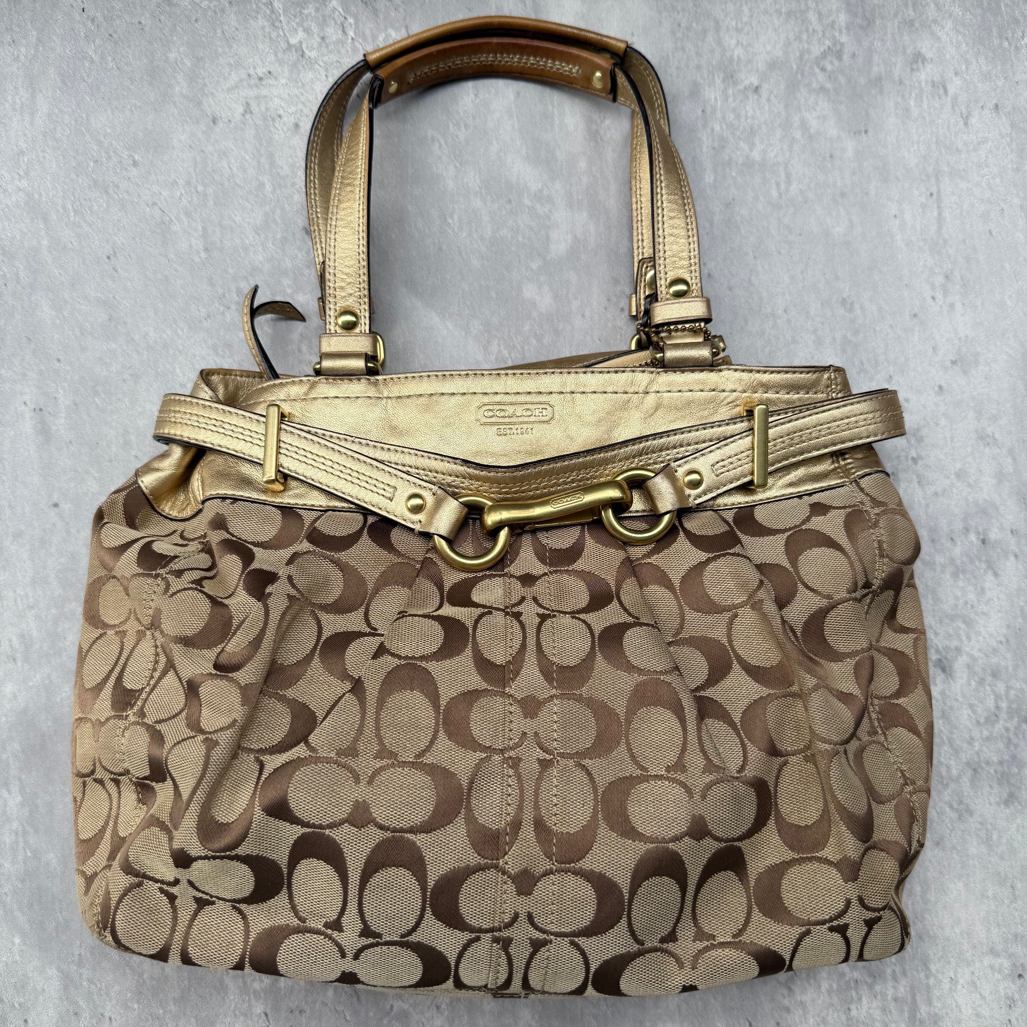 Coach Signature Hampton Carryall Tote Bag in beige canvas with metallic gold leather trim and gold-tone hardware.