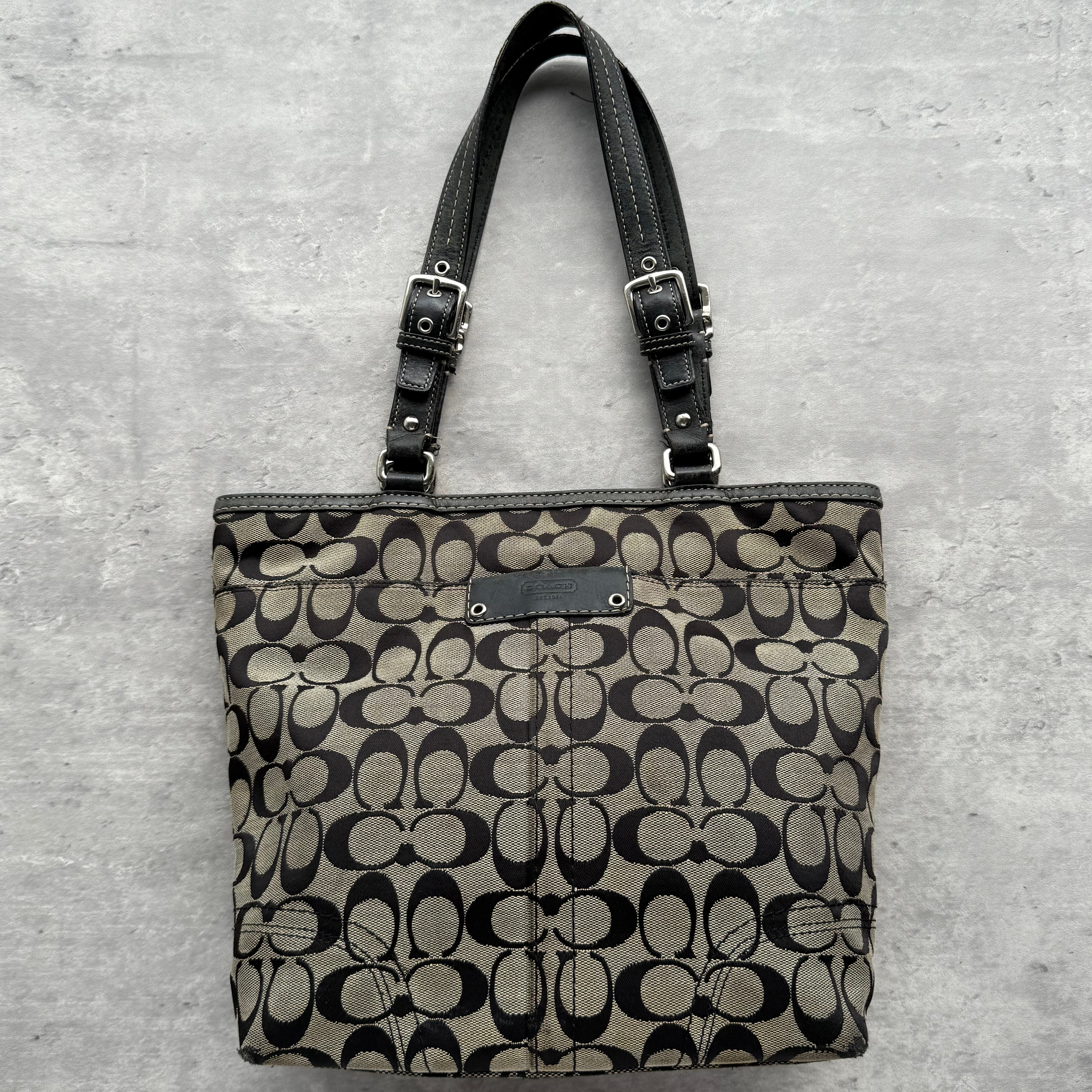 Coach Signature Hamptons Tote Bag Grey/Black in jacquard canvas with leather trim, featuring adjustable buckle straps, spacious interior, and exterior slip pocket.