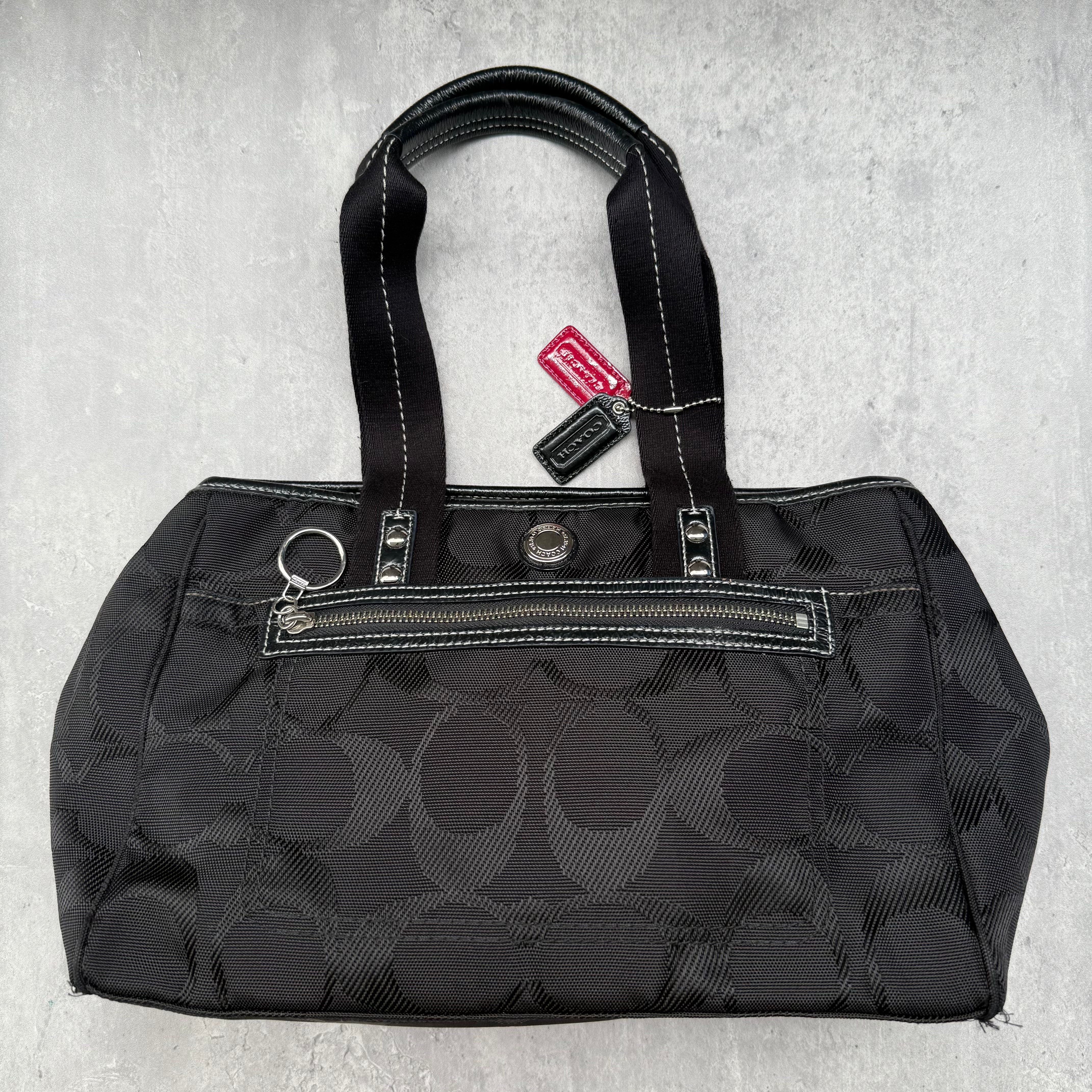 Coach Signature Kyra Daisy Canvas Tote Bag in black with pink interior lining and silver-tone hardware.