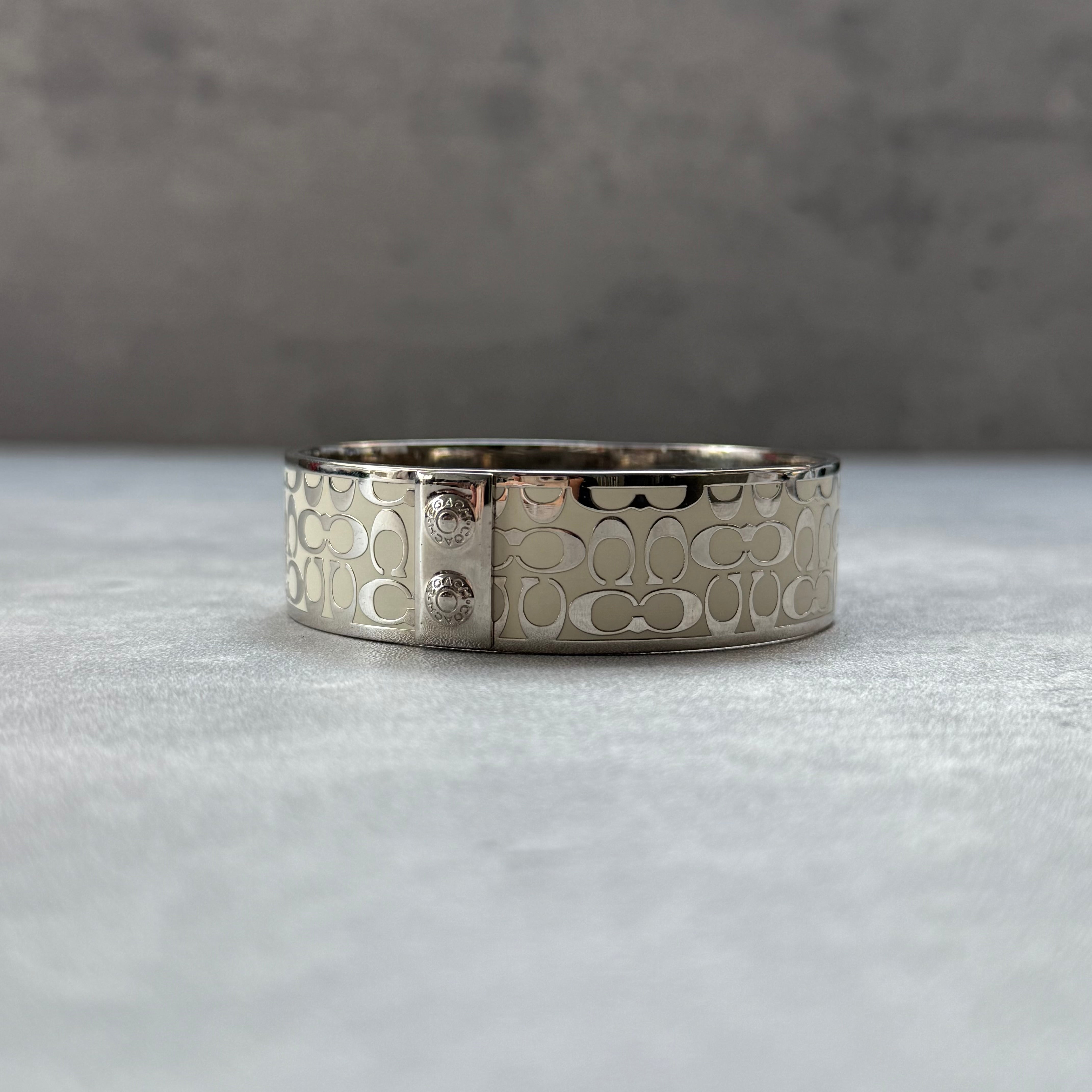 Coach Signature Monogram C Bracelet White/Silver, wide metal band with engraved C monogram design and enamel finish.