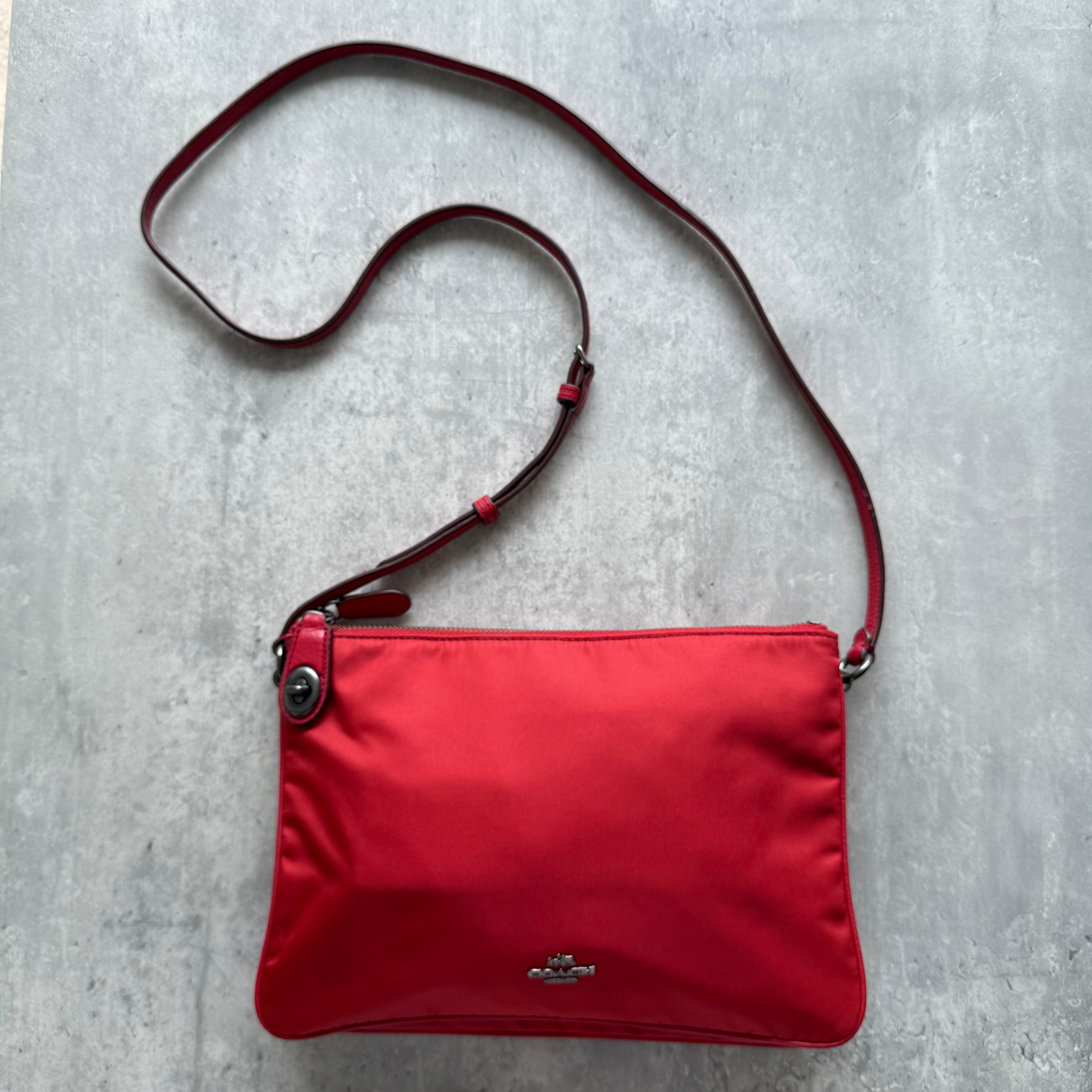 Coach Signature Nylon Crossbody Bag in red with silver-tone hardware and adjustable strap.