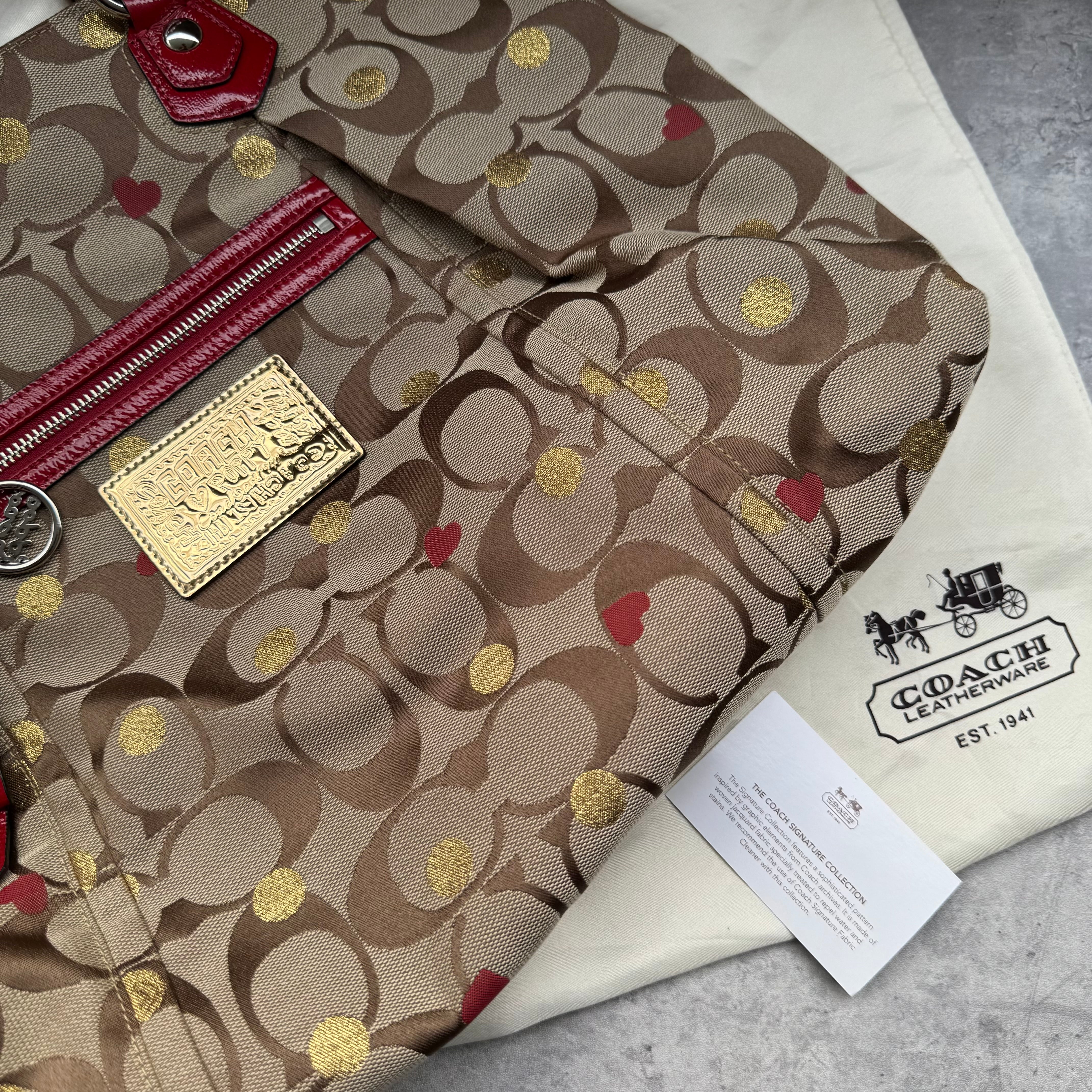 Coach Signature Poppy Laura Secret Admirer Tote Bag in brown monogram canvas with red and gold heart dot accents and red patent leather trim.