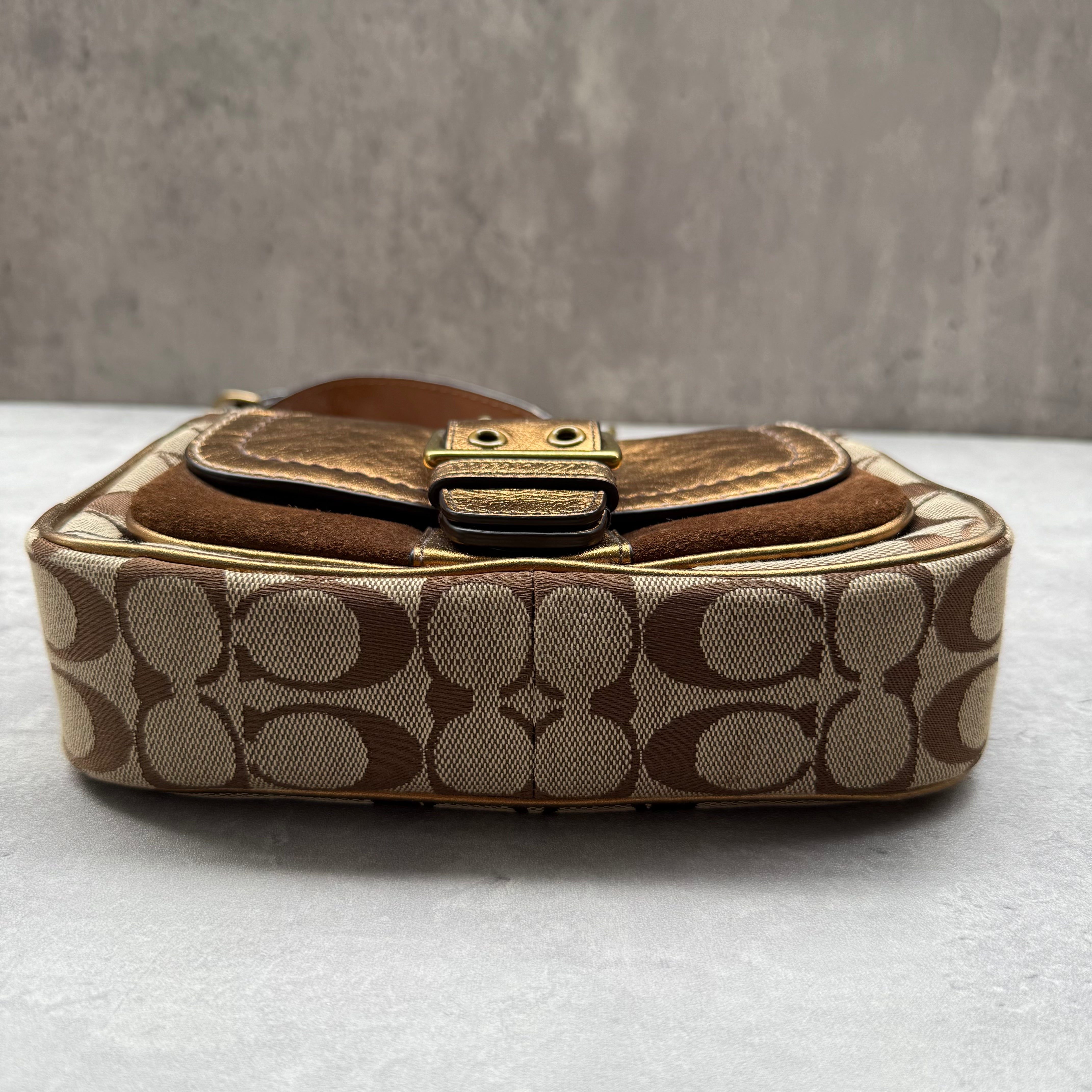 Coach Signature Shoulder Bag in beige canvas with gold metallic front buckle pocket, brown suede accents, and short strap.