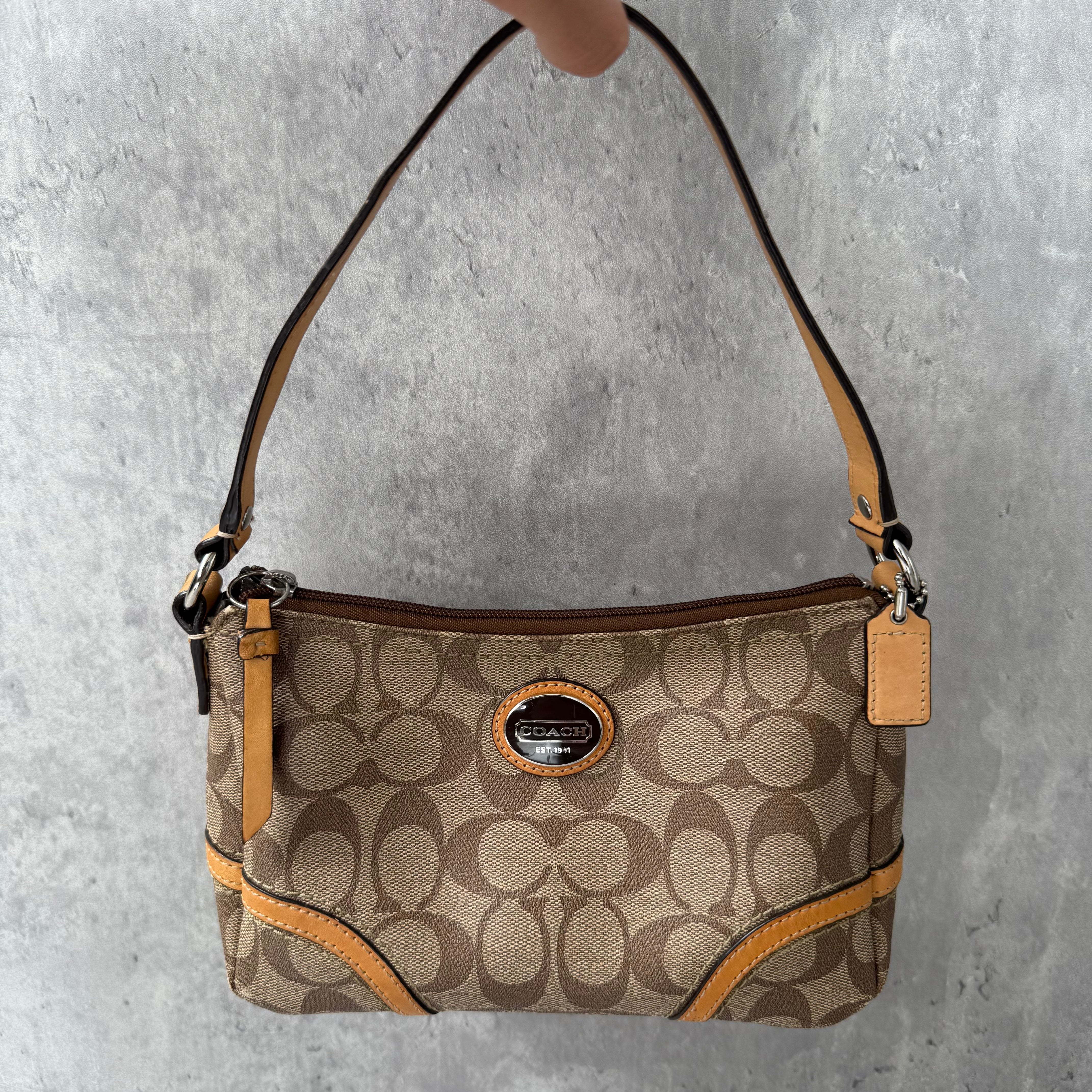 Coach Signature Sufflette Leather Shoulder Bag in beige with monogram canvas, tan leather trim, zip-top closure, and interior slip pocket