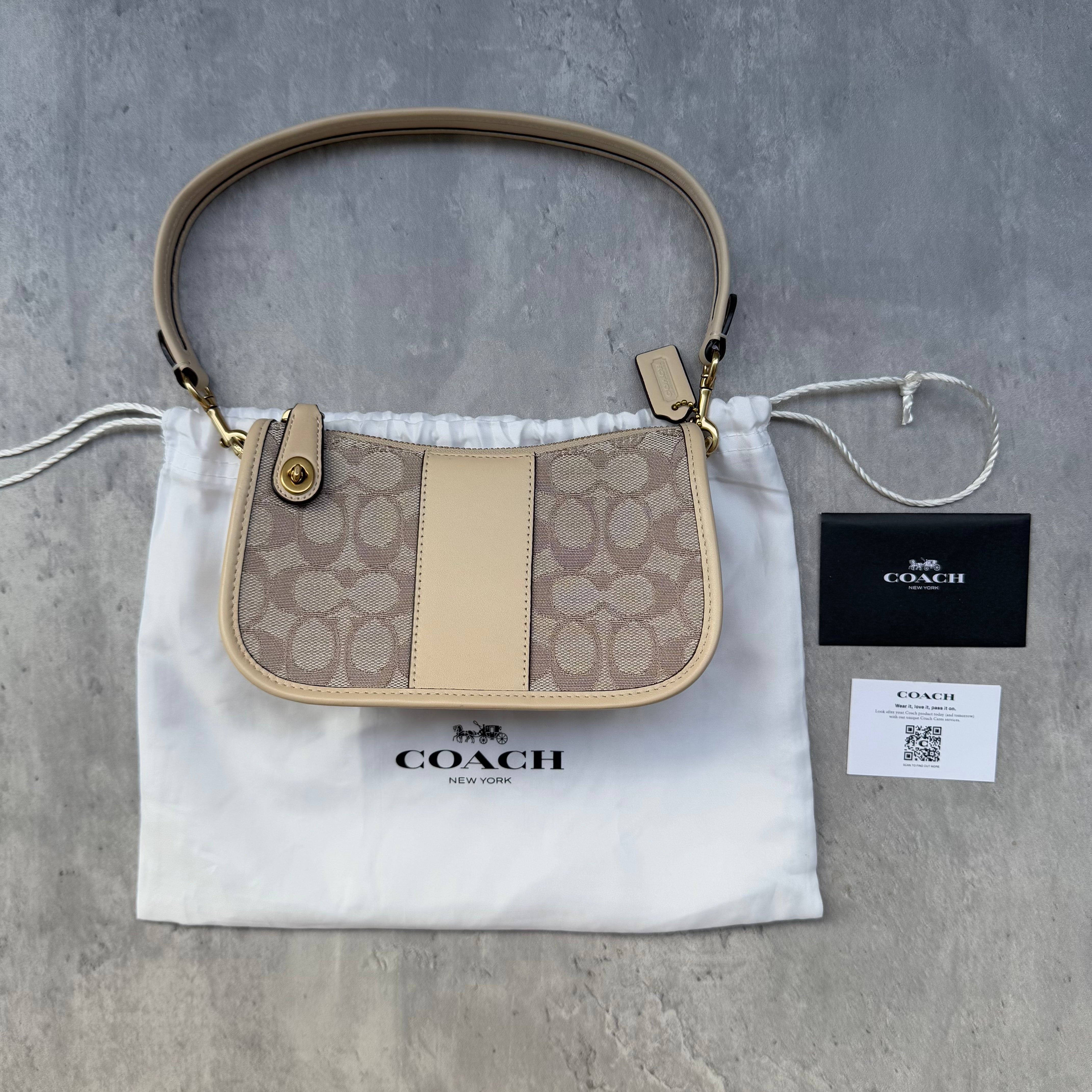Coach Signature Swinger 20 Shoulder Bag in cream jacquard with leather trim, gold-tone hardware, and detachable strap.