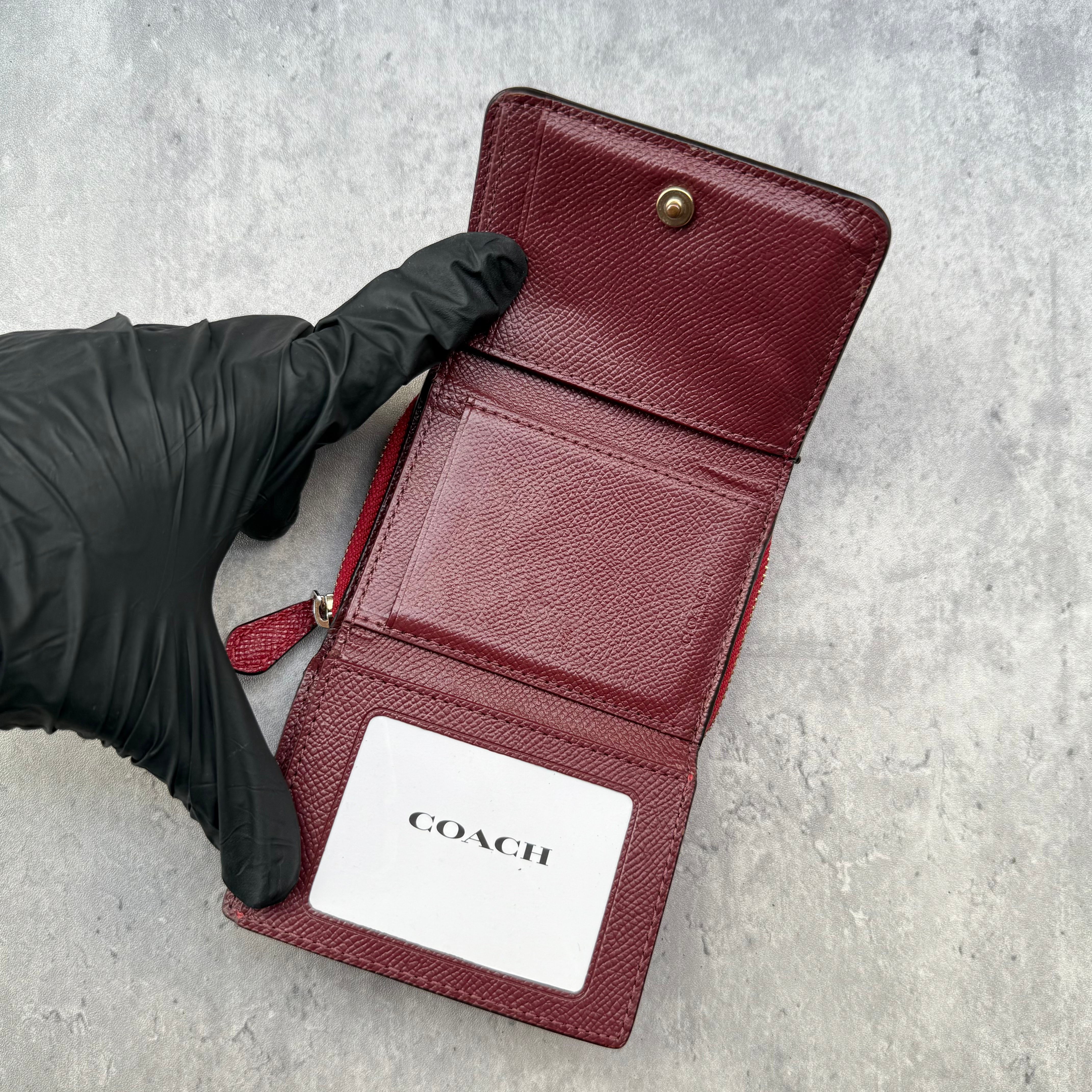 Coach Small Trifold Wallet in Red Pebbled Leather with gold-tone logo and zip coin pocket.