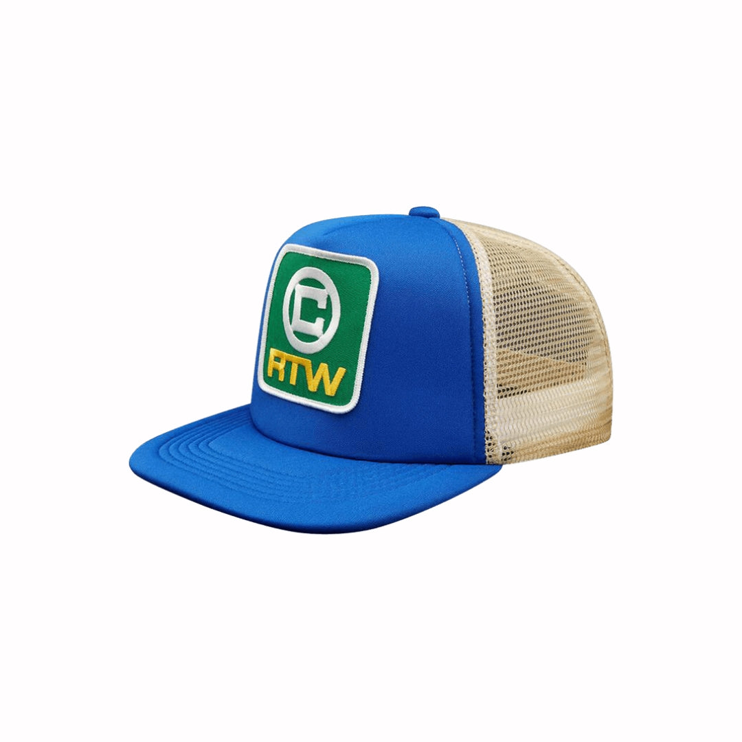 Corteiz RTW Blue Trucker Hat with embroidered green RTW logo patch, blue front panel, and beige mesh back.