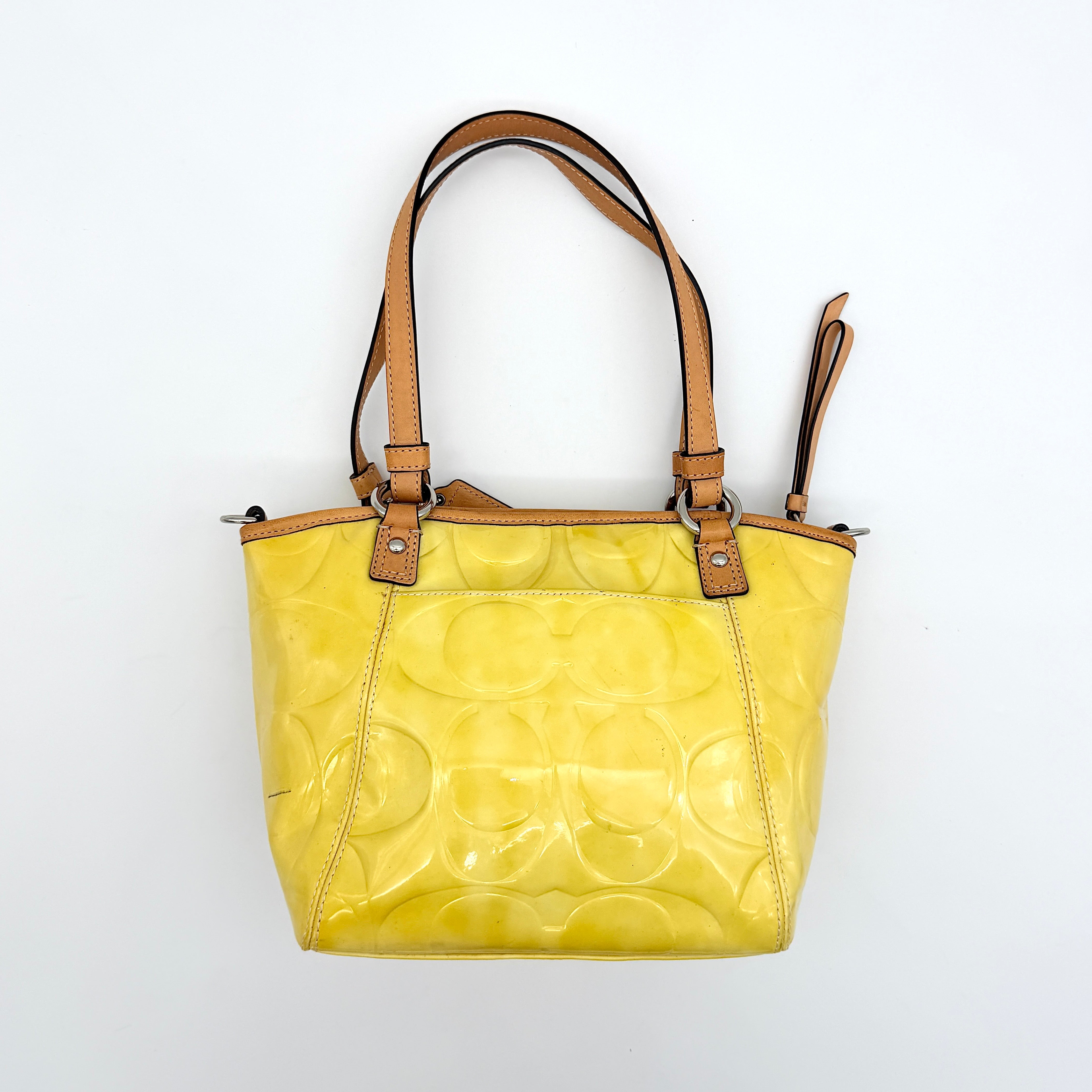 Coach Peyton tote in glossy yellow patent leather with tan handles and detachable strap, shown with blush pink interior.