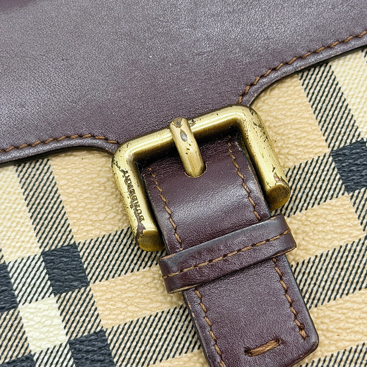 Burberry Nova Check wallet in beige and brown with leather trim and brass buckle detail photographed on white background.