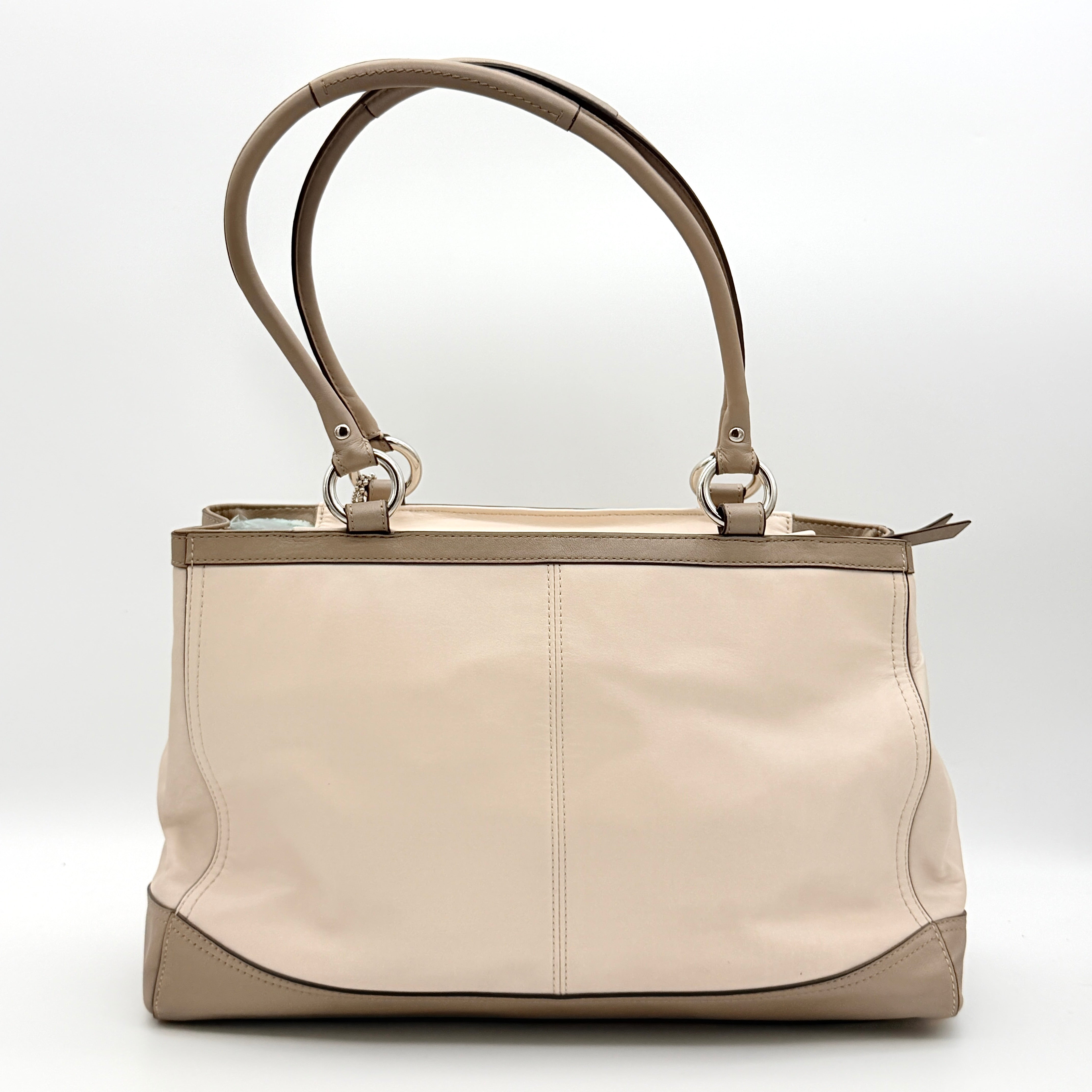 Coach Park Carryall shoulder bag in cream and grey leather with dual handles and silver hardware, photographed on a white background.