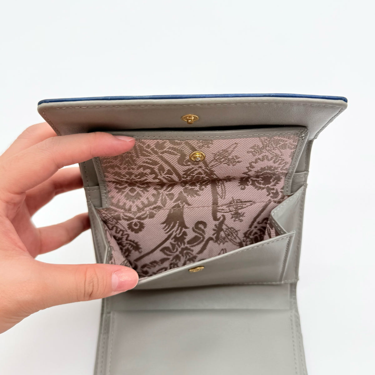 Vivienne Westwood blue leather trifold wallet with gold Orb emblem, shown with original box and documents.
