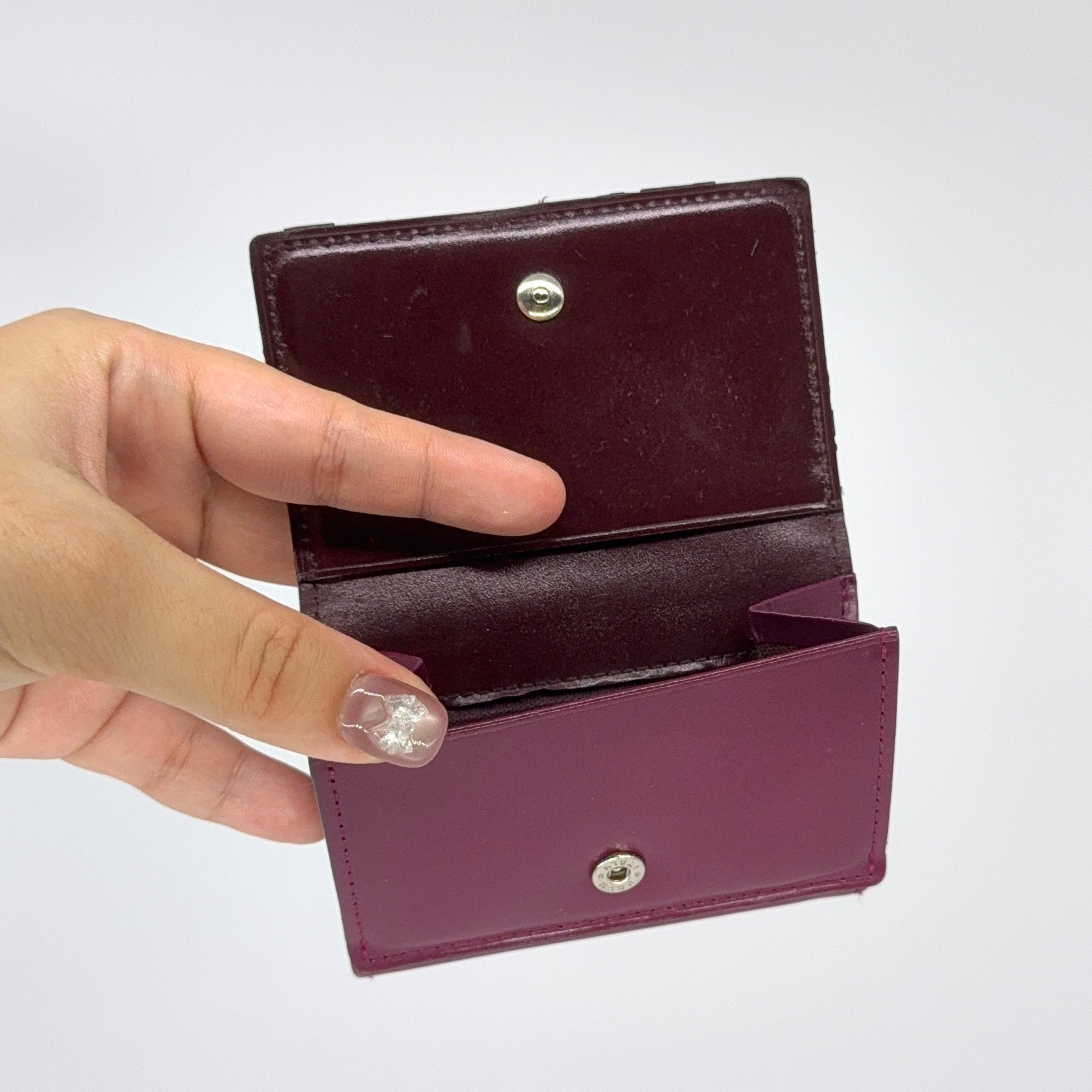 Vivienne Westwood Signature Orb Wallet in glossy purple leather with silver orb emblem on the front flap.