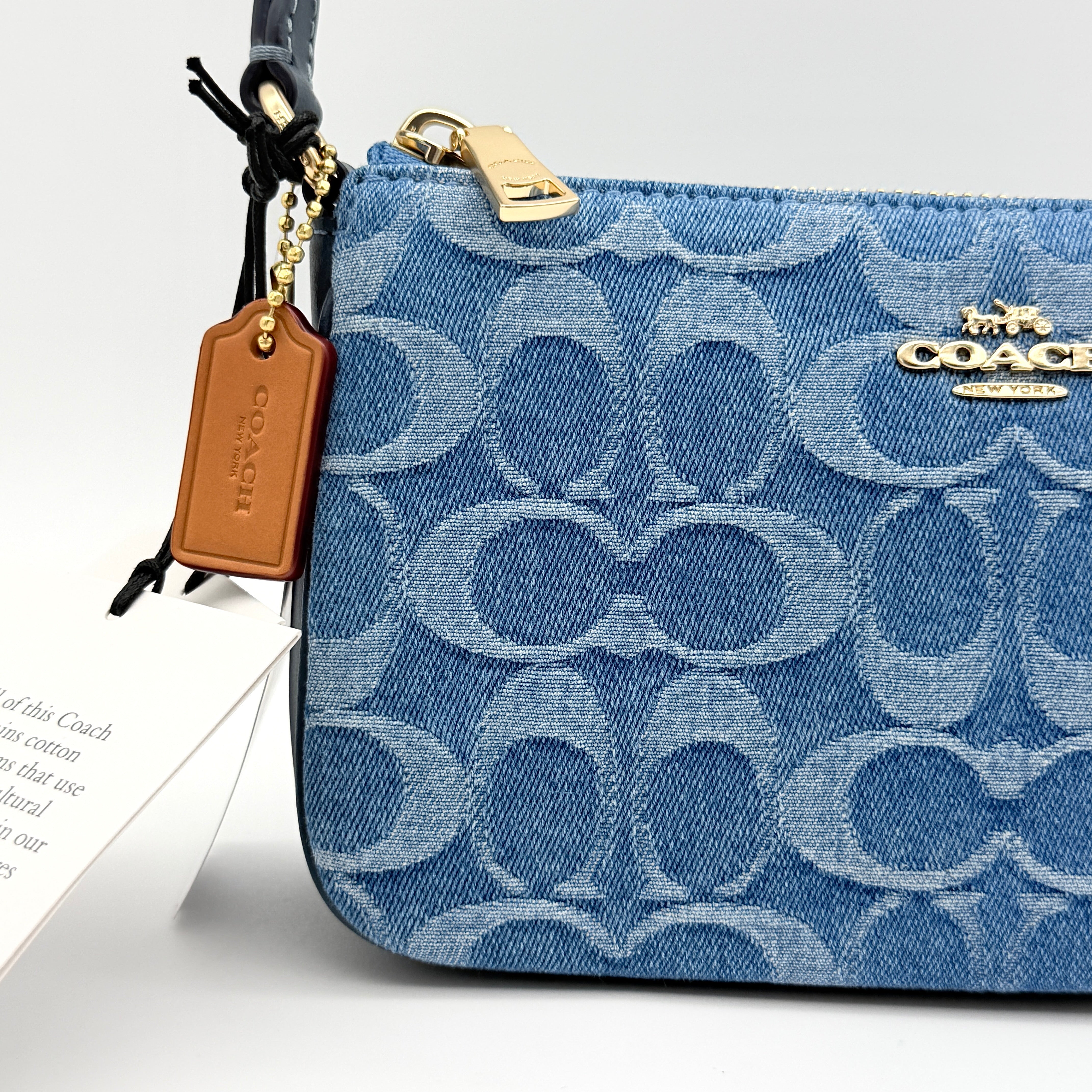 Coach Nolita 19 shoulder bag in blue denim jacquard with monogram print and gold hardware, shown with original packaging.