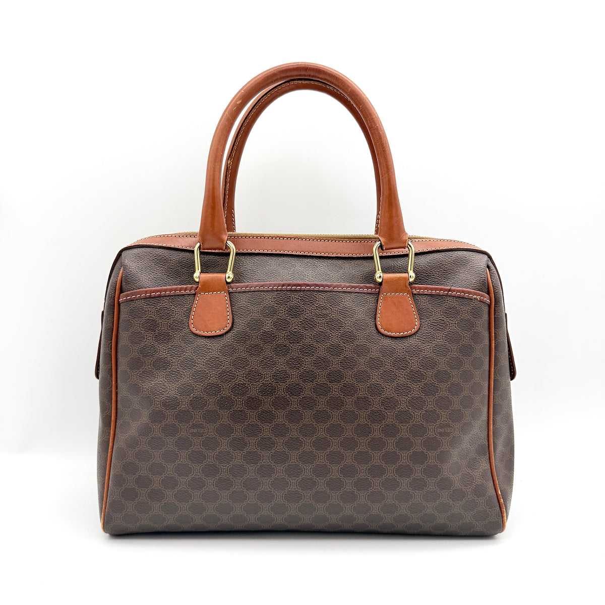 Celine Triomphe Macadam Boston Bag in brown coated canvas with tan leather handles and gold hardware on a white background.
