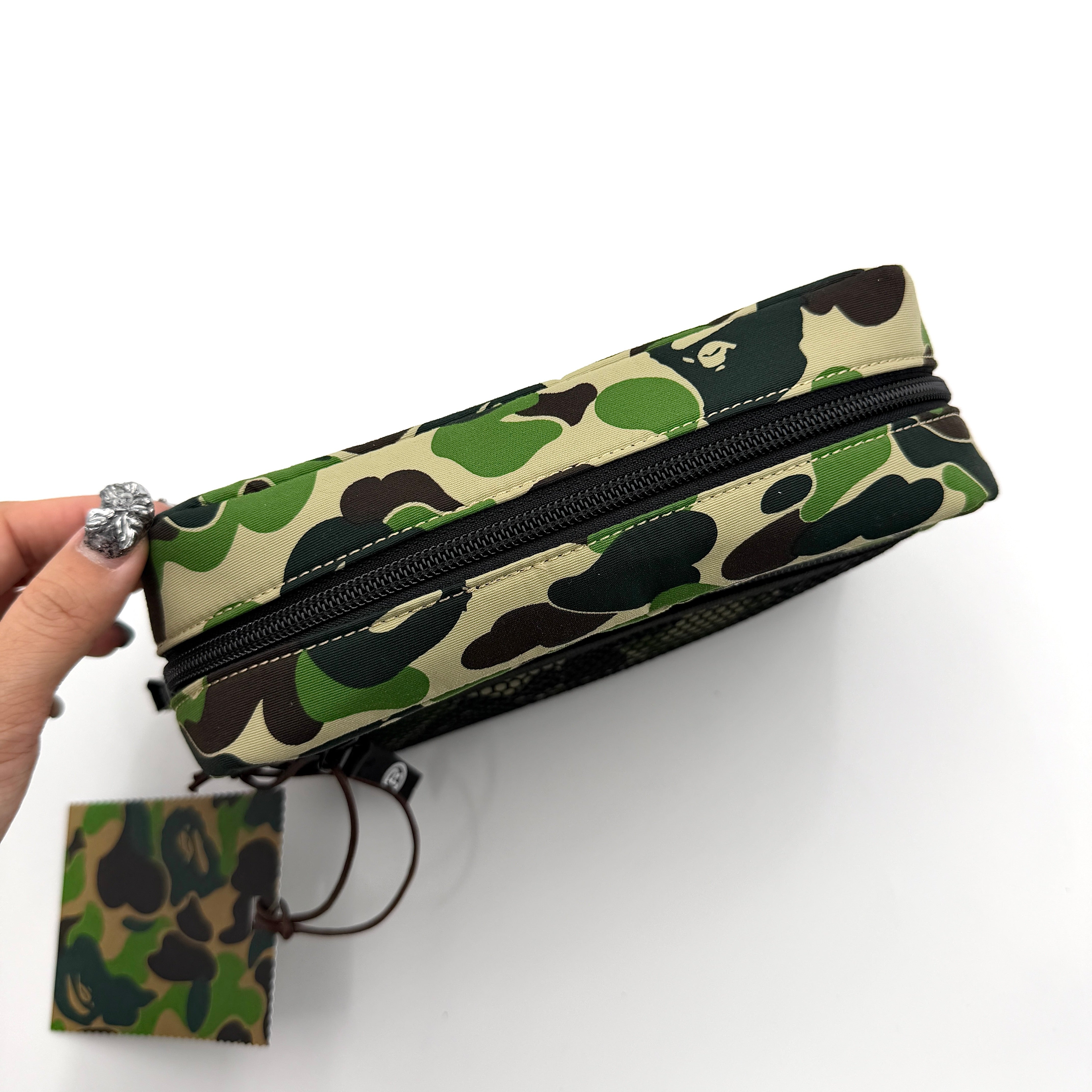 BAPE ABC Camo Pouch in green camouflage with mesh front pocket and embroidered A Bathing Ape logo.