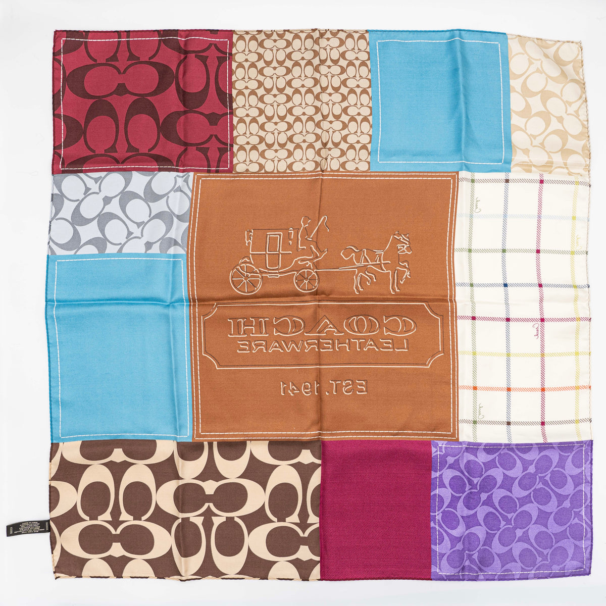 Coach patchwork silk scarf featuring multicolour monogram and checked panels, shown laid flat.