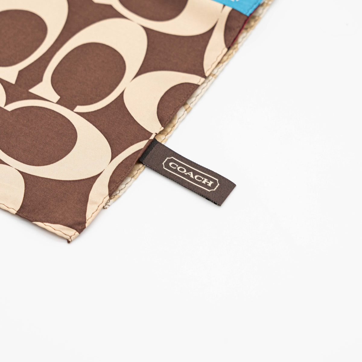 Coach patchwork silk scarf featuring multicolour monogram and checked panels, shown laid flat.