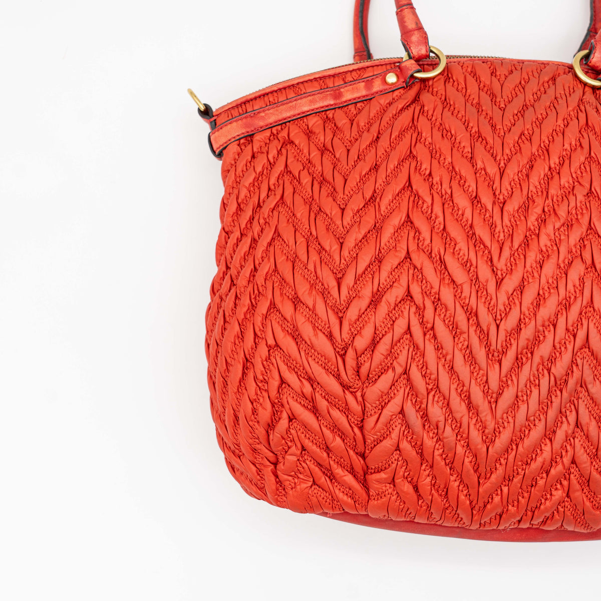 Coach Madison 2Way shoulder bag in rich red quilted texture with gold hardware, top handles, and detachable strap, displayed on a white background.