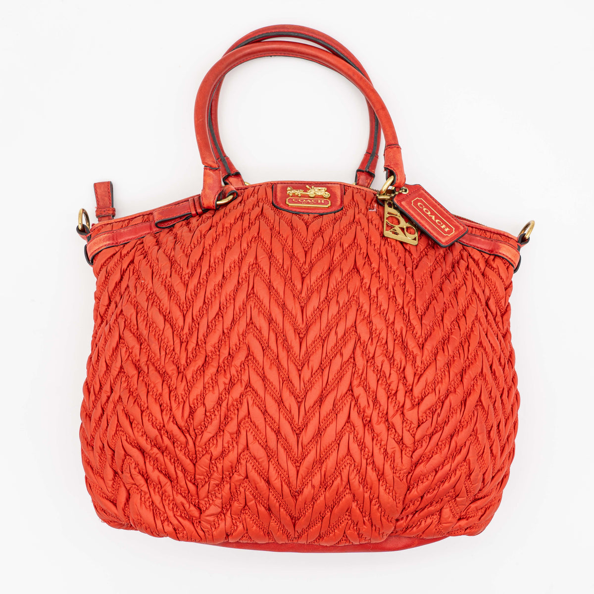 Coach Madison 2Way shoulder bag in rich red quilted texture with gold hardware, top handles, and detachable strap, displayed on a white background.