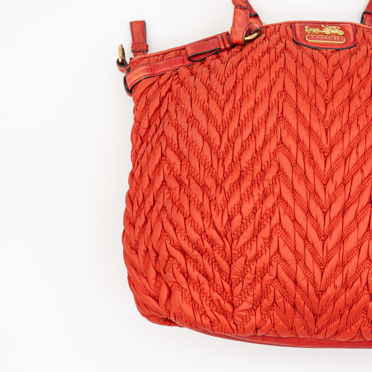 Coach Madison 2Way shoulder bag in rich red quilted texture with gold hardware, top handles, and detachable strap, displayed on a white background.