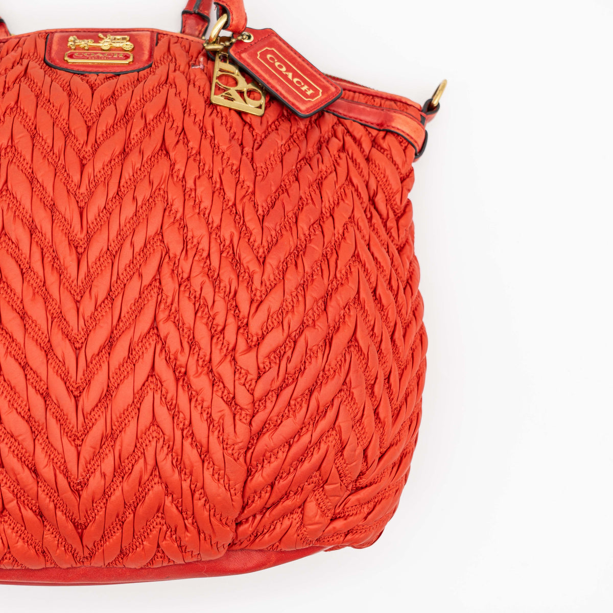 Coach Madison 2Way shoulder bag in rich red quilted texture with gold hardware, top handles, and detachable strap, displayed on a white background.