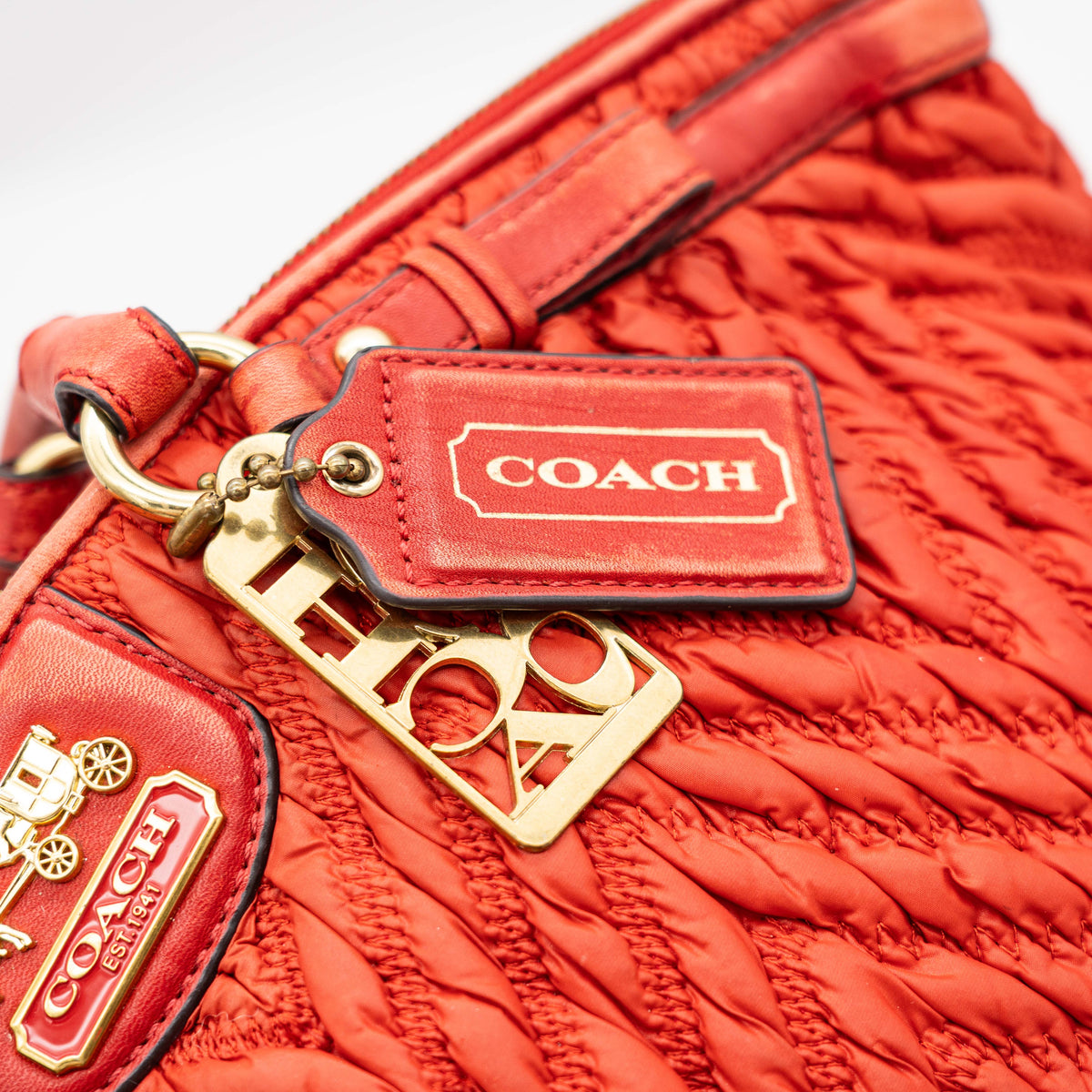 Coach Madison 2Way shoulder bag in rich red quilted texture with gold hardware, top handles, and detachable strap, displayed on a white background.