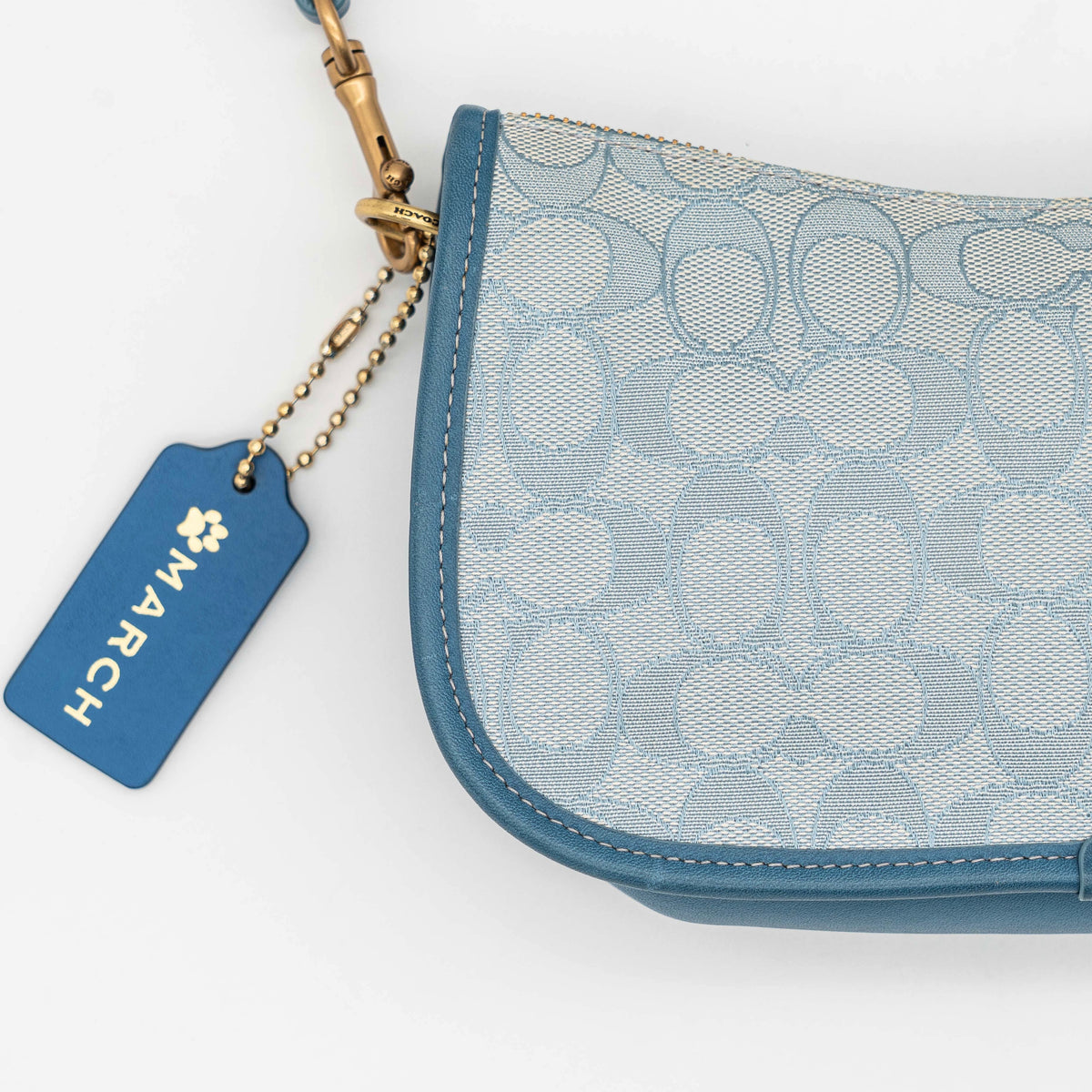 Coach 2Way Signature Swinger Shoulder Bag in light blue monogram canvas and leather with dinosaur and rainbow patches, shown with detachable strap.