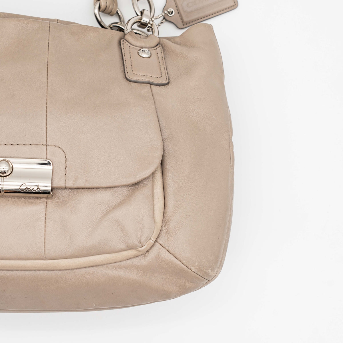 Coach Kristin East West Shoulder Bag in beige leather with silver-tone hardware and double handles.