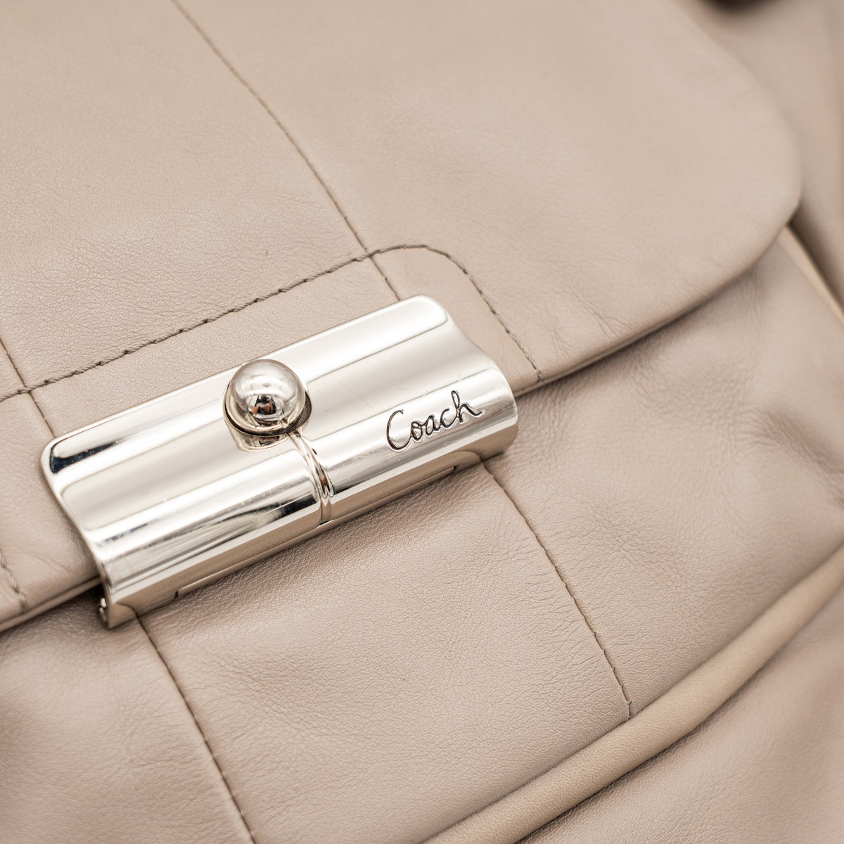 Coach Kristin East West Shoulder Bag in beige leather with silver-tone hardware and double handles.