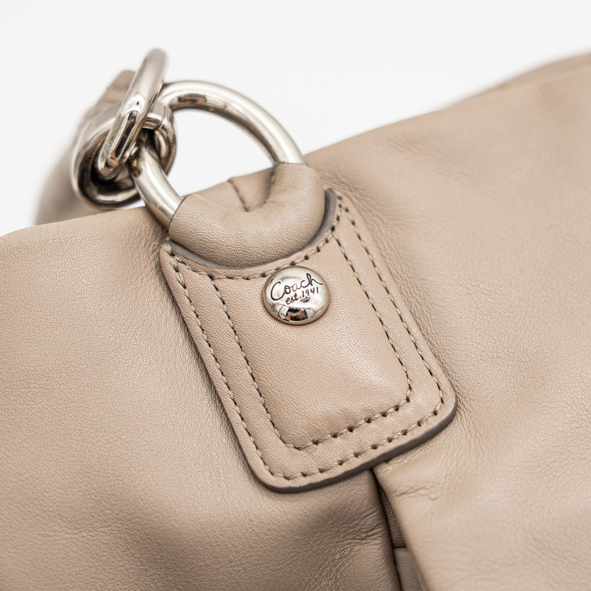 Coach Kristin East West Shoulder Bag in beige leather with silver-tone hardware and double handles.