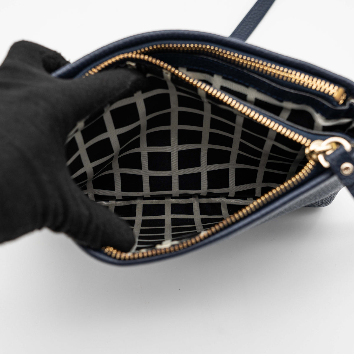 Kate Spade navy blue crossbody bag in pebbled leather, shown with adjustable strap and gold-tone accents.
