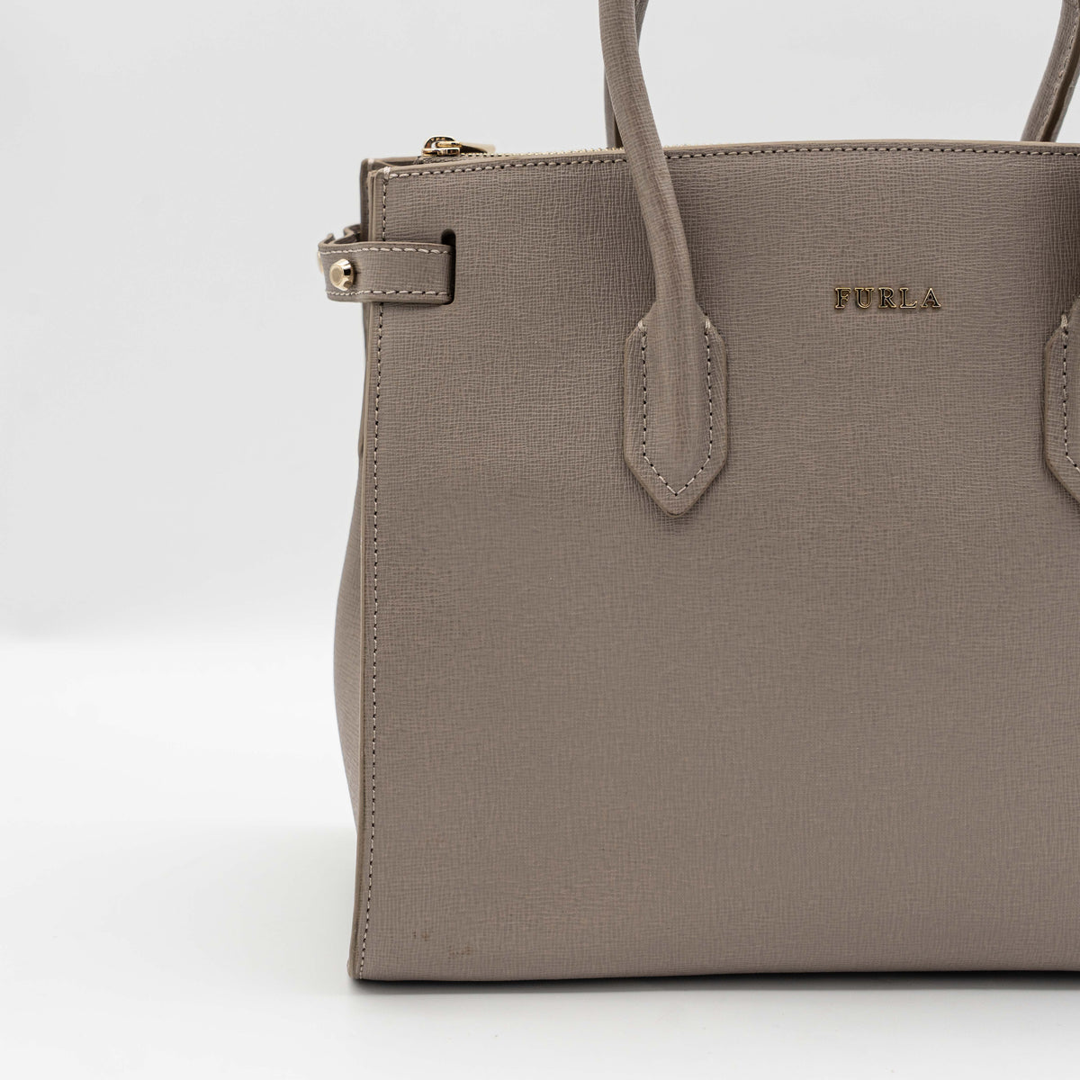 Furla grey Pin tote bag with top handles, gold hardware, and detachable strap against a white background.