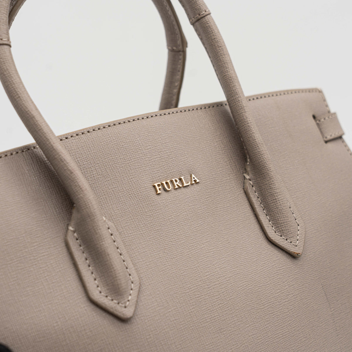 Furla grey Pin tote bag with top handles, gold hardware, and detachable strap against a white background.