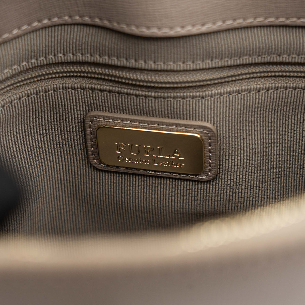 Furla grey Pin tote bag with top handles, gold hardware, and detachable strap against a white background.