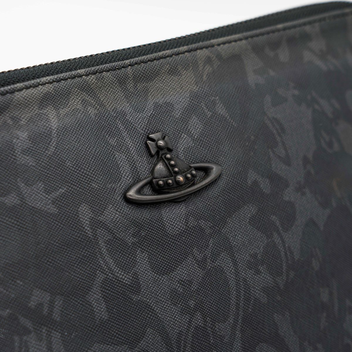 Vivienne Westwood clutch bag in grey and black graphic camouflage with matte black Orb logo and leather trim, styled against a white background.