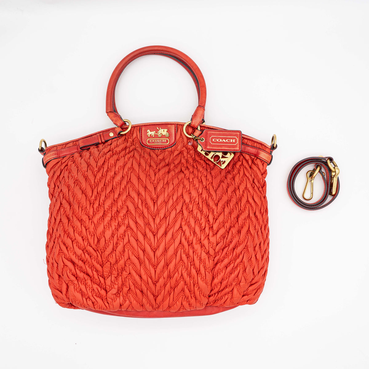 Coach Madison 2Way shoulder bag in rich red quilted texture with gold hardware, top handles, and detachable strap, displayed on a white background.