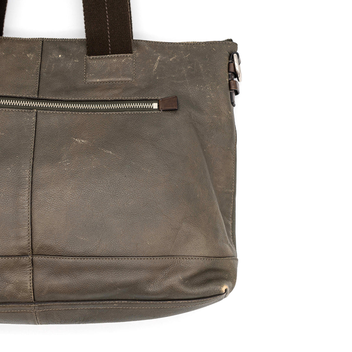 Coach brown leather tote bag with double handles and front zip pocket, shown on a white background.