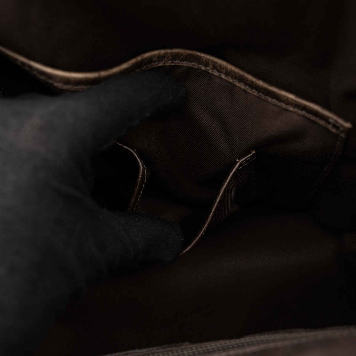 Coach brown leather tote bag with double handles and front zip pocket, shown on a white background.