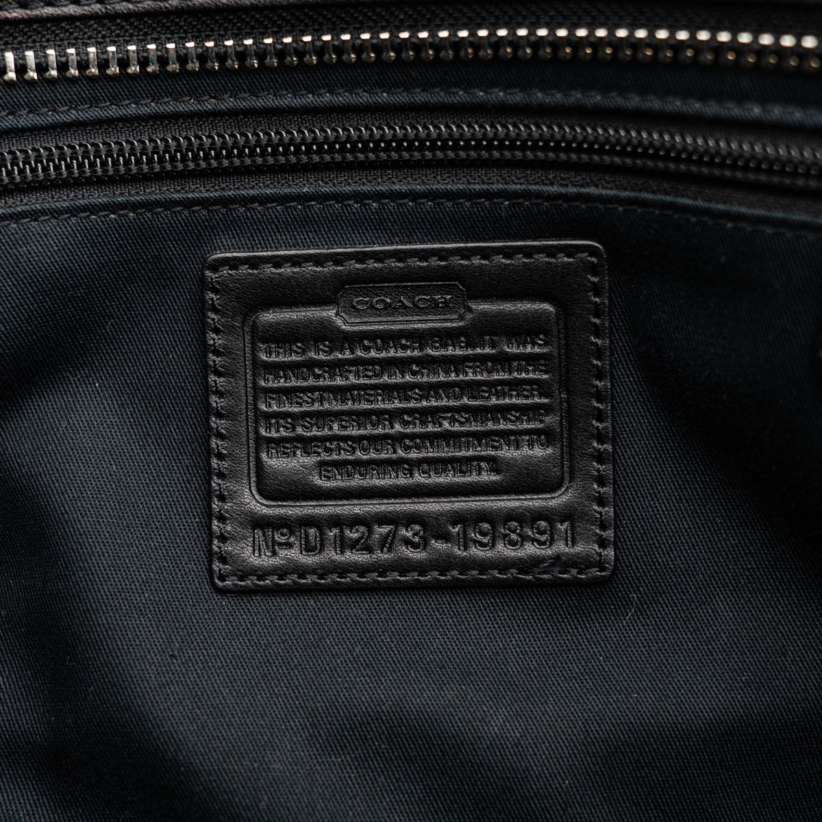 Coach Legacy Candace Carryall in black leather with double tassel charm and silver hardware, photographed against a white background.
