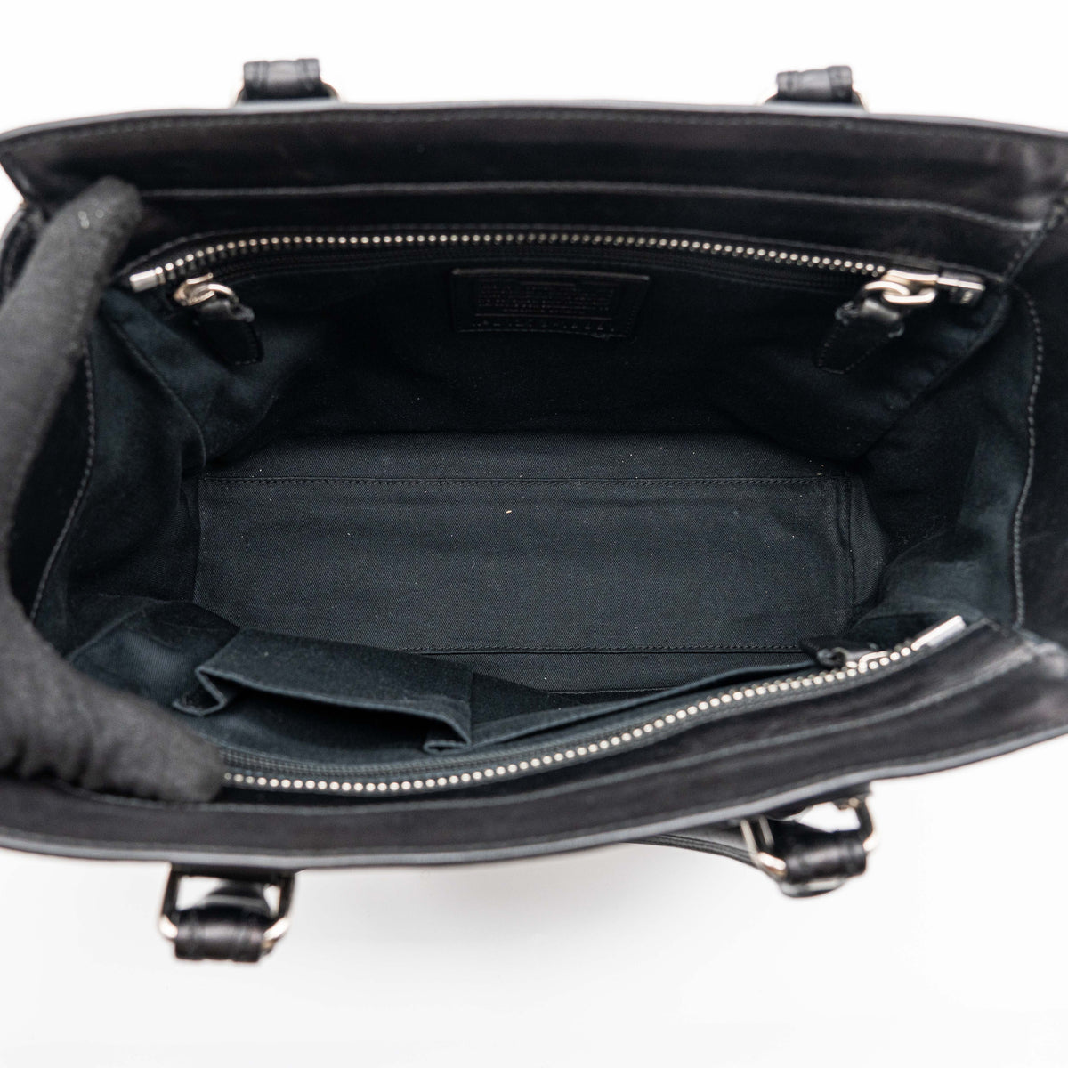 Coach Legacy Candace Carryall in black leather with double tassel charm and silver hardware, photographed against a white background.