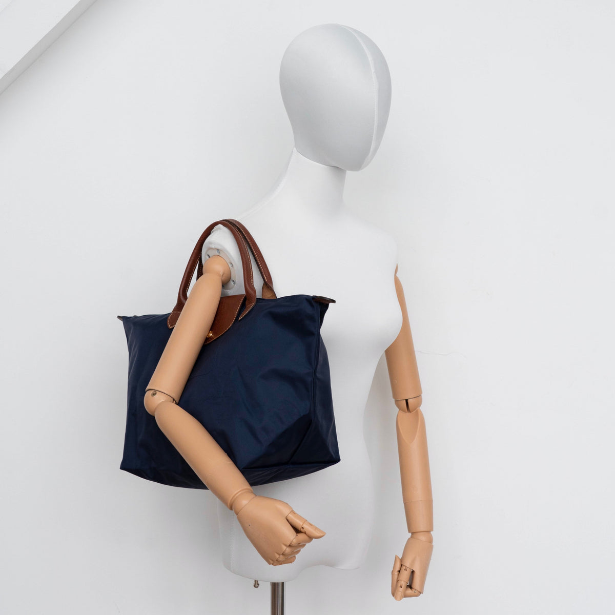 Longchamp Le Pliage Original handbag in navy blue nylon with brown leather handles and trim, shown against a white background.