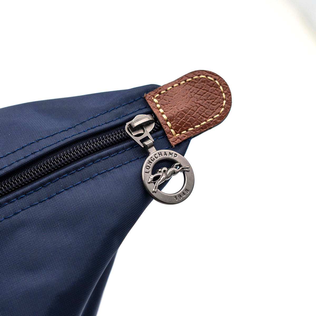 Longchamp Le Pliage Original handbag in navy blue nylon with brown leather handles and trim, shown against a white background.