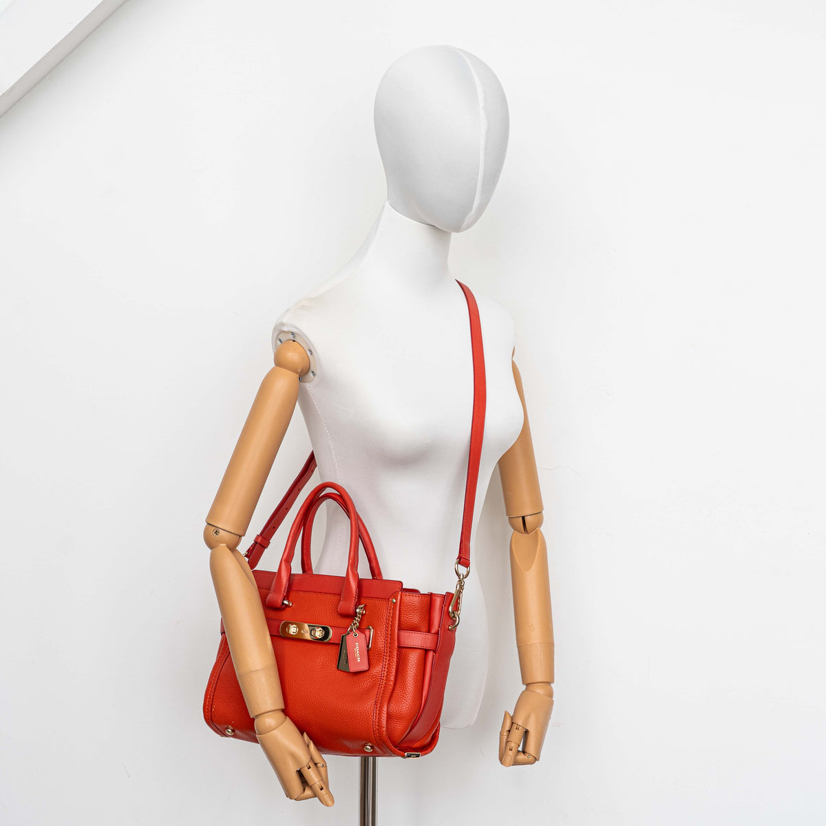 Coach Swagger 27 Carryall in textured red leather with gold hardware, shown with detachable shoulder strap.