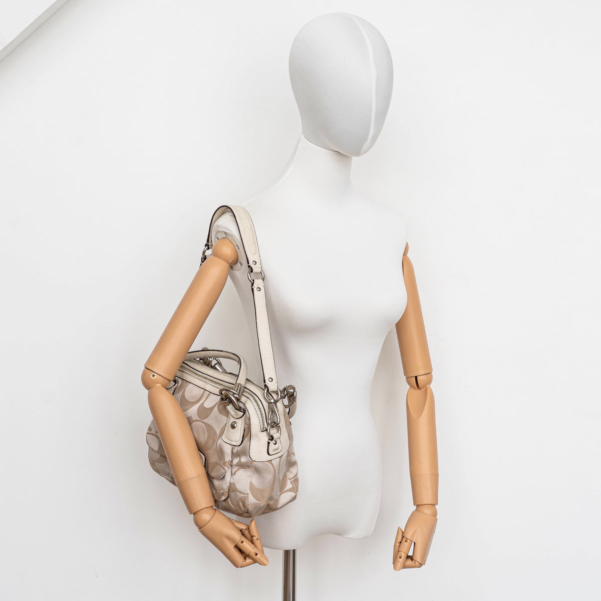 Coach Signature Kristin Satchel handbag in beige and cream jacquard with leather trim and detachable strap, displayed against a white background.